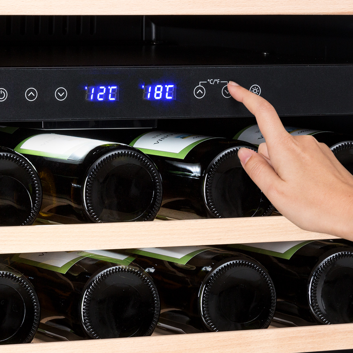 Una mano regola le impostazioni della temperatura di un frigo bar.
