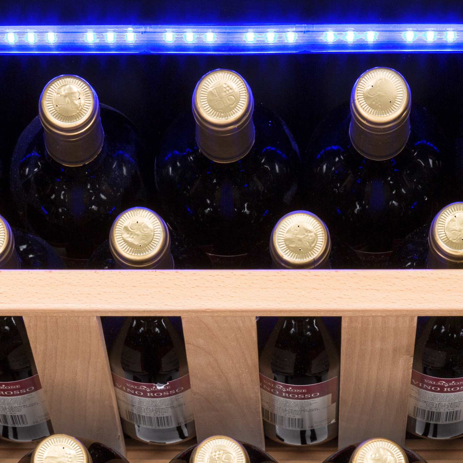 Bottiglie di vino in una cantinetta in legno, con una luce blu sopra.