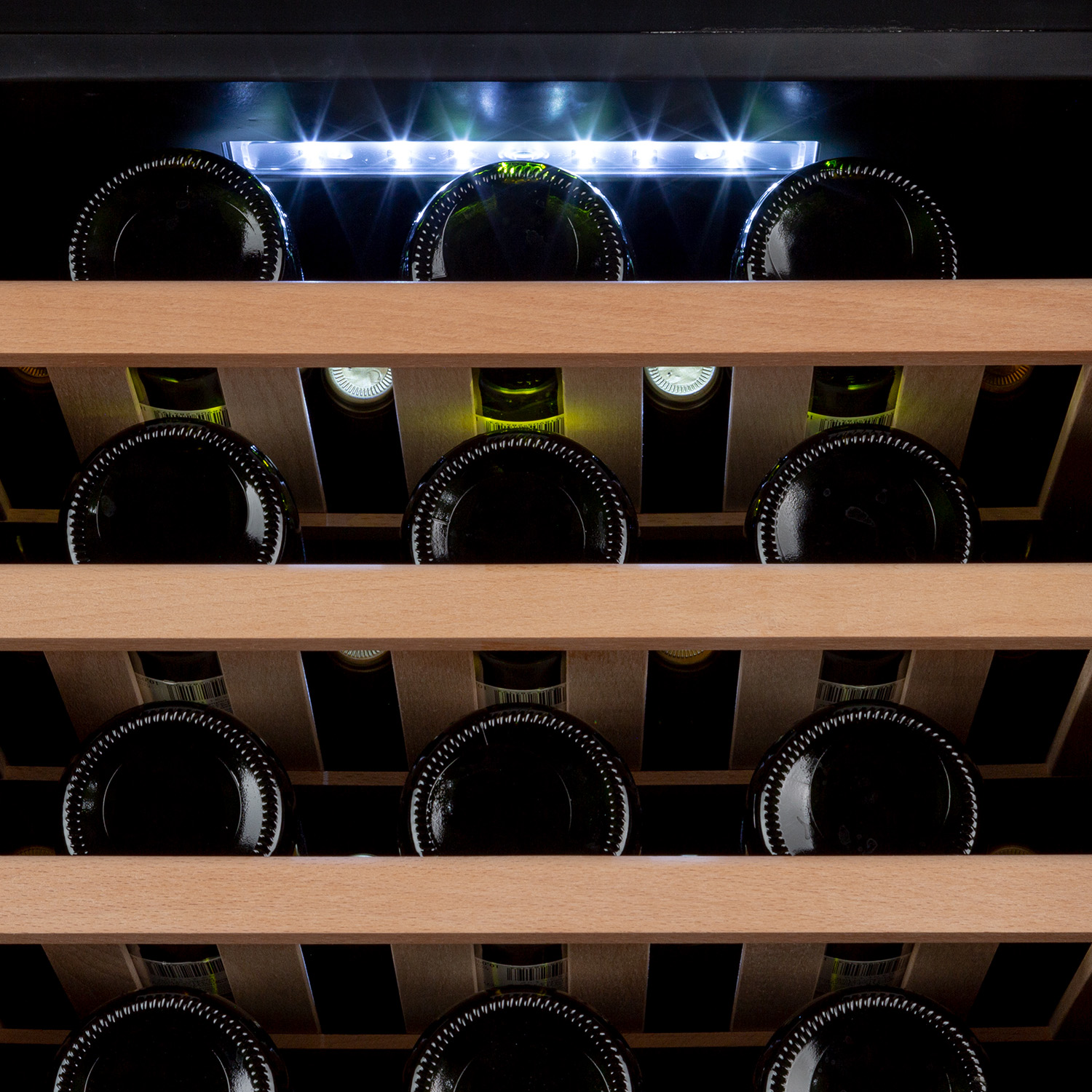 Un frigorifero per vini con molte bottiglie di vino all'interno su ripiani in legno.