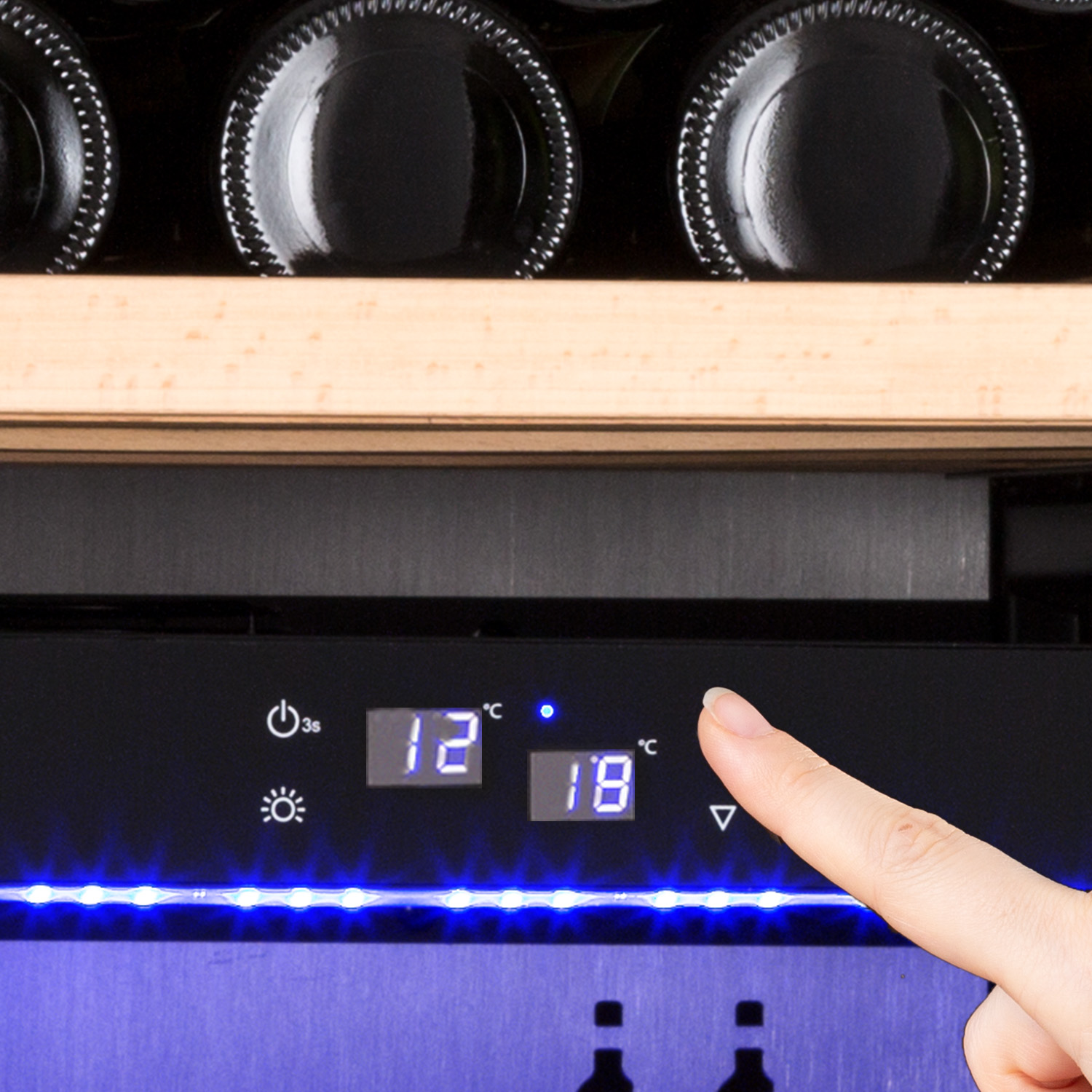 Una mano regola il display digitale di un refrigeratore per vino, che mostra le impostazioni della temperatura.