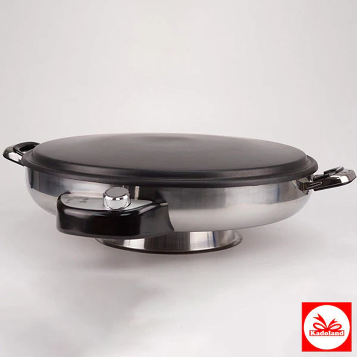 A silver and black cooking appliance with a black lid, sitting on a white surface.