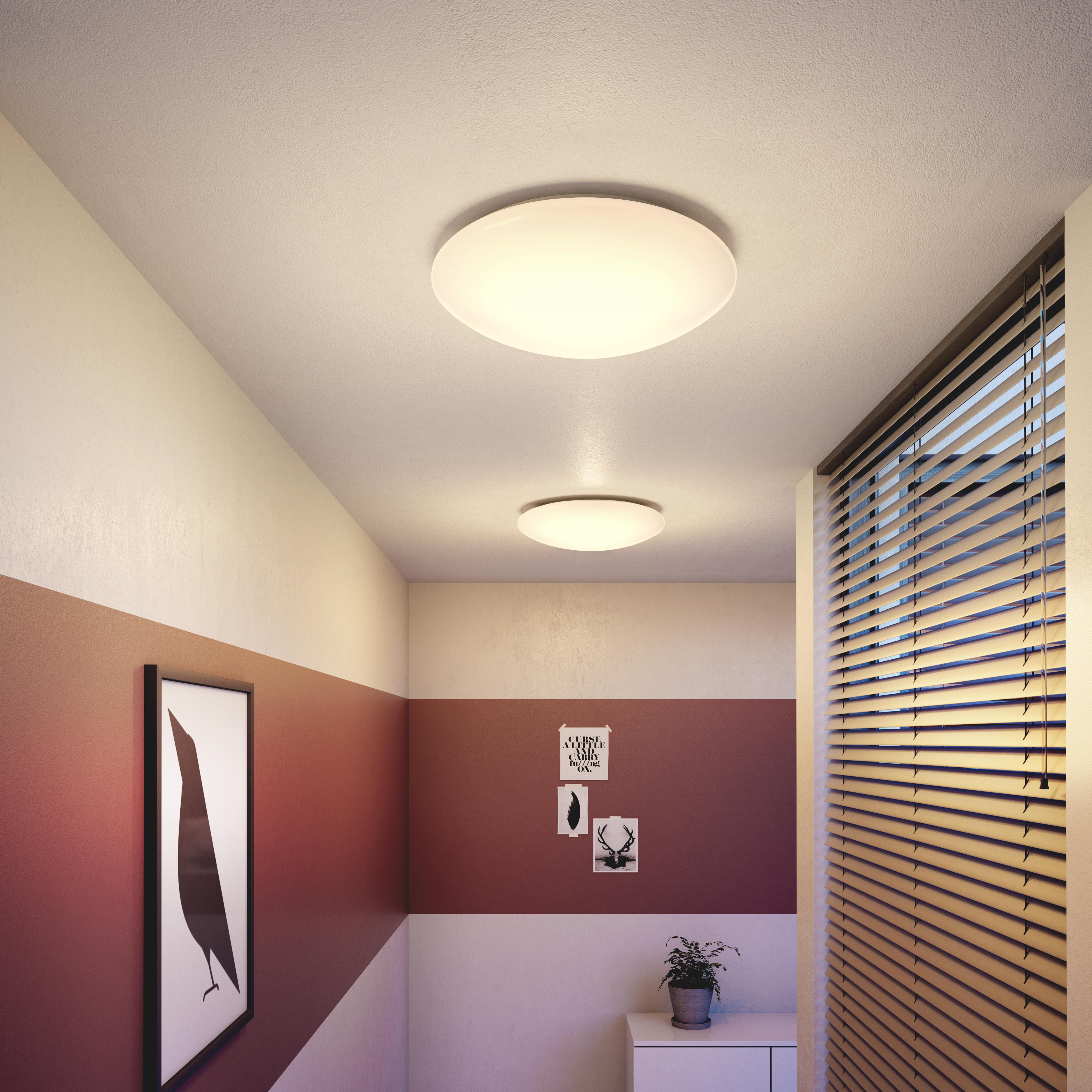 Dos luces de techo en pasillo. Pared a rayas rojas y beige con obra de arte y persiana.