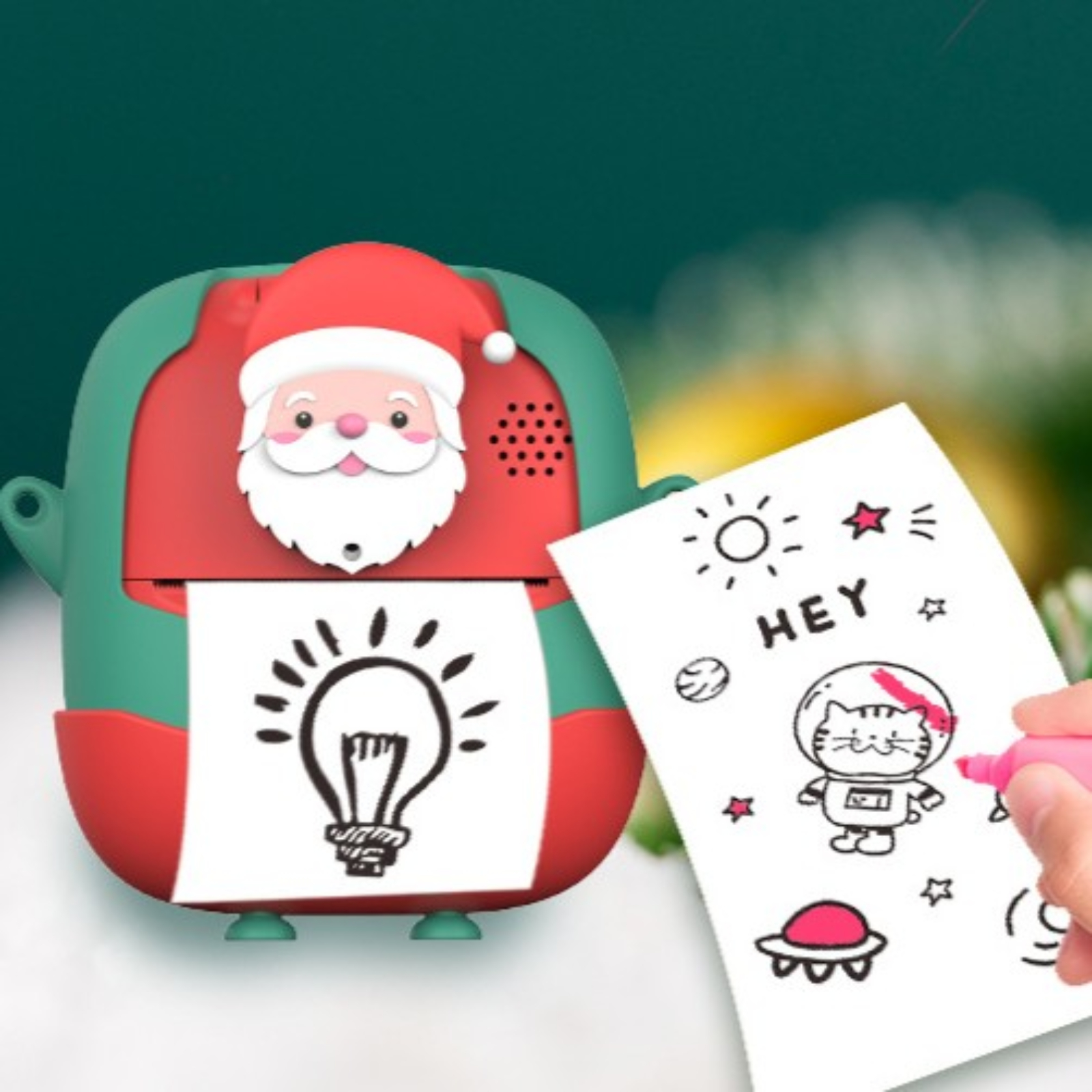 Ein rotes und grünes Spielzeug mit einem Weihnachtsmannkopf. Ein Papier mit einer Zeichnung einer Glühbirne und eines Katzen-Astronauten.