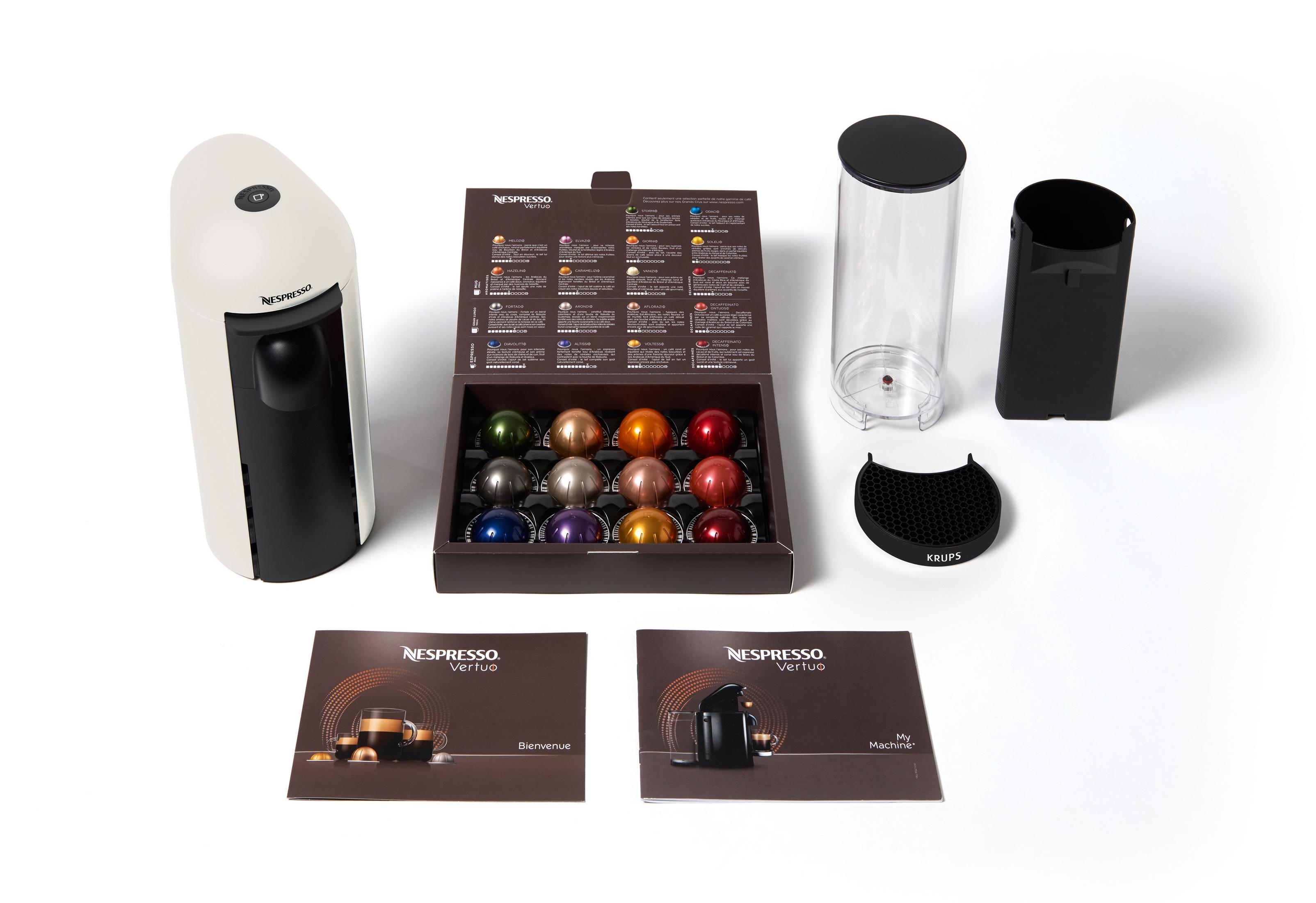 Macchina da caffè Nespresso e accessori. Include una scatola di capsule e manuali.