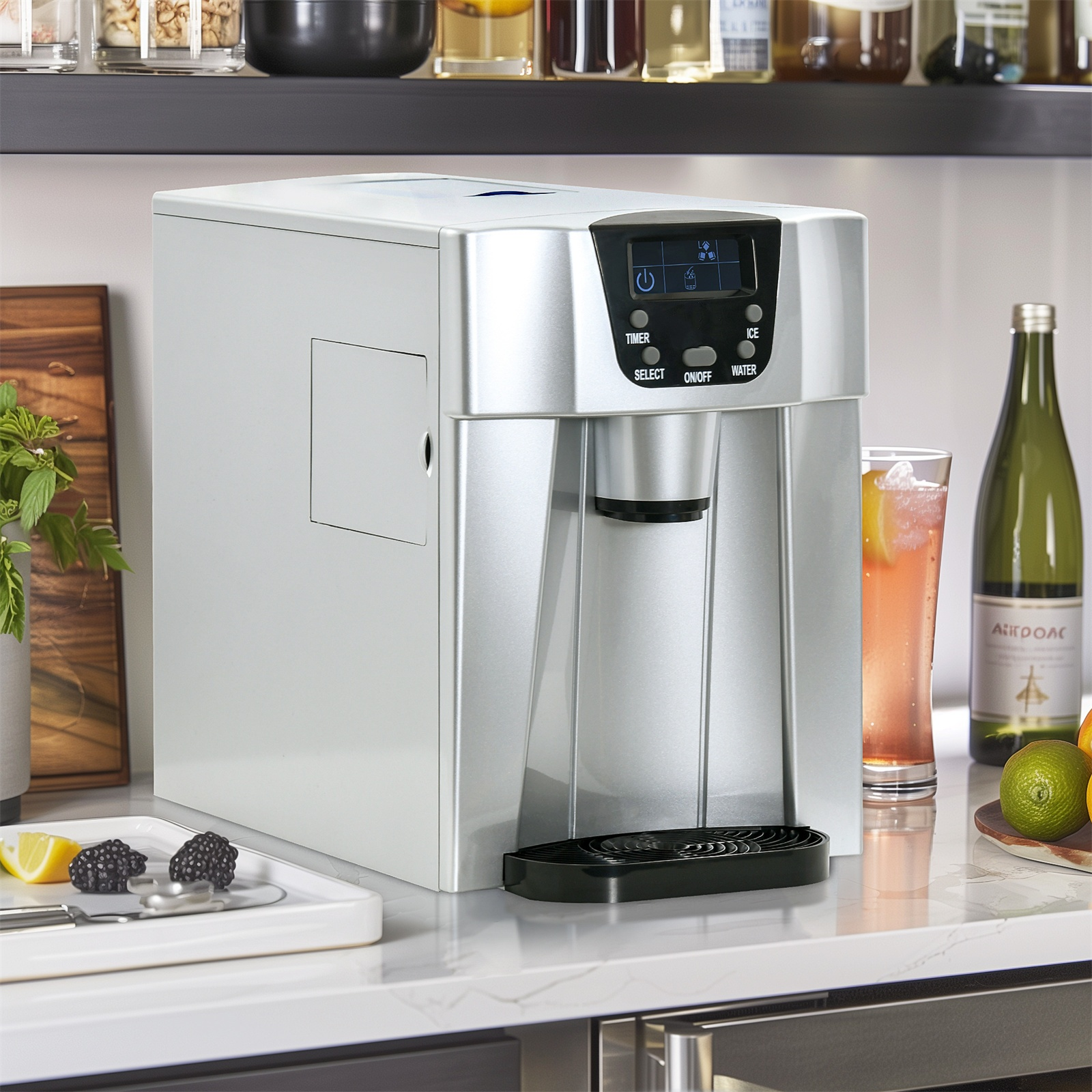 Silberner Eisbereiter mit Digitalanzeige, Glas mit Getränk und Flasche auf einer weißen Arbeitsplatte.