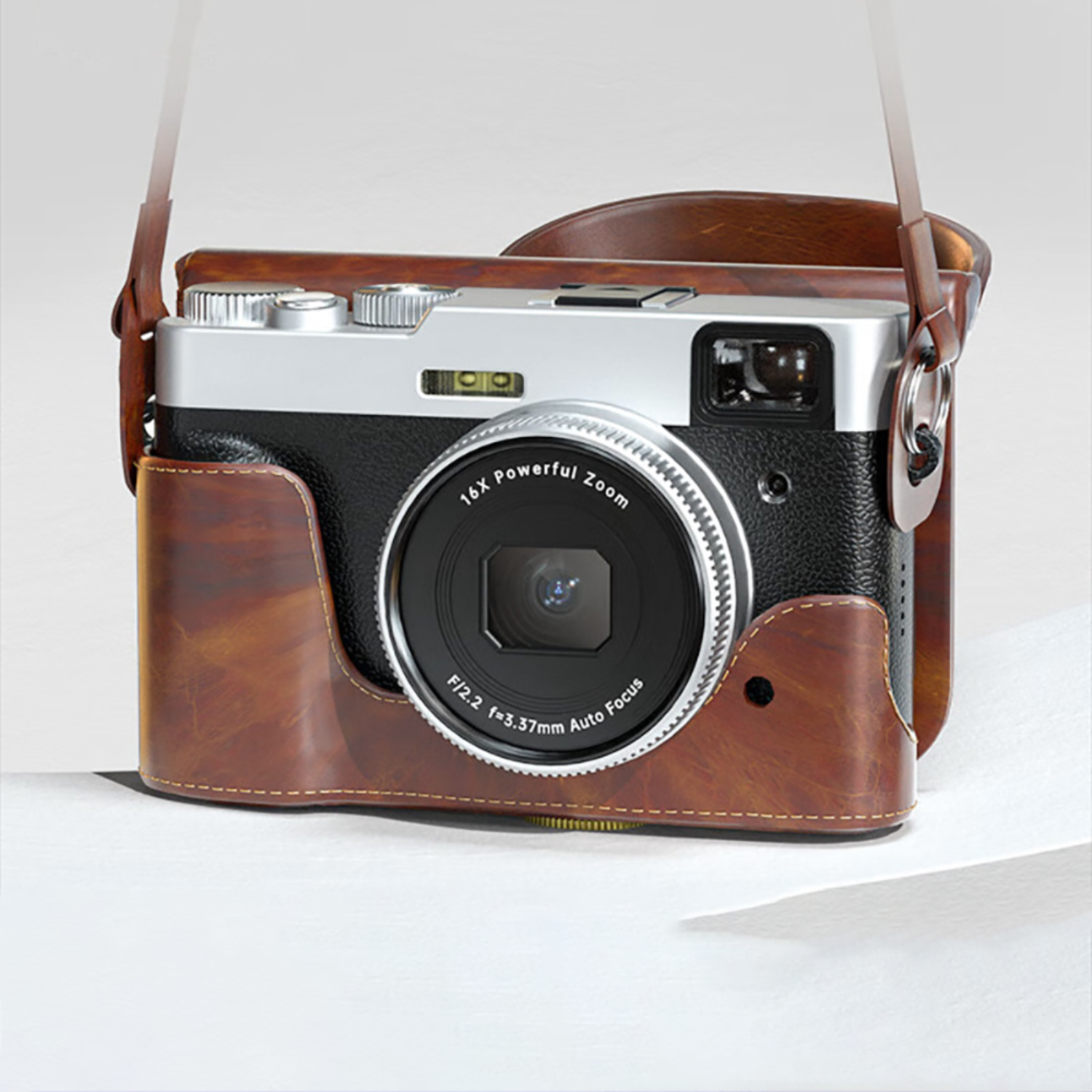 Eine silberne und schwarze Kamera in einer braunen Ledertasche mit Riemen.