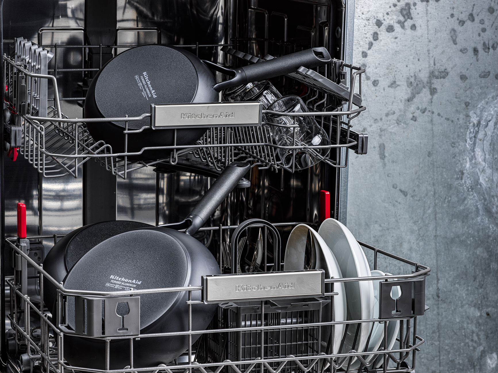 Geschirrspüler mit Pfannen, Tellern und Gläsern. Marke KitchenAid sichtbar.