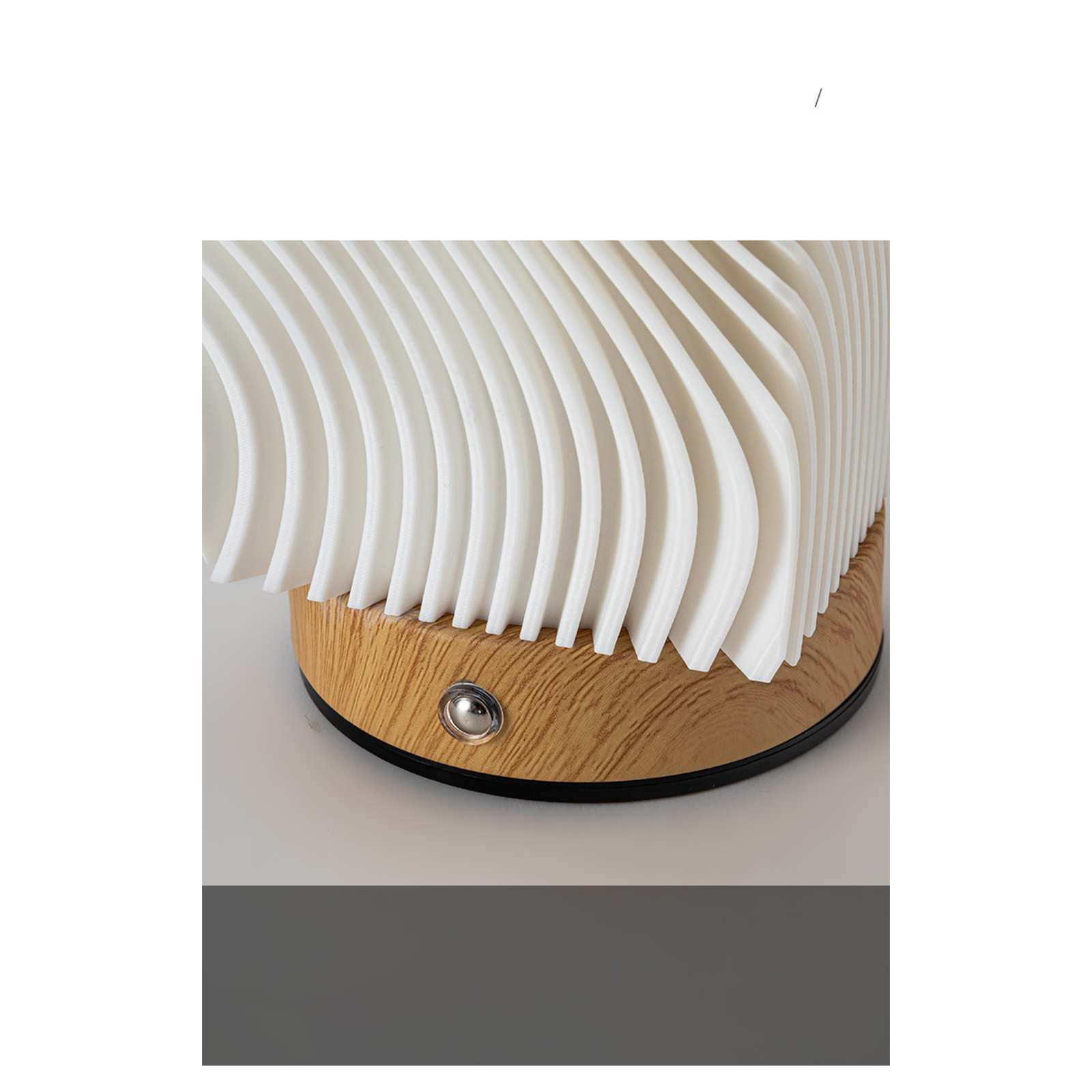 Eine weiße, modern aussehende Lampe mit Holzsockel und einem kleinen Silberknopf.