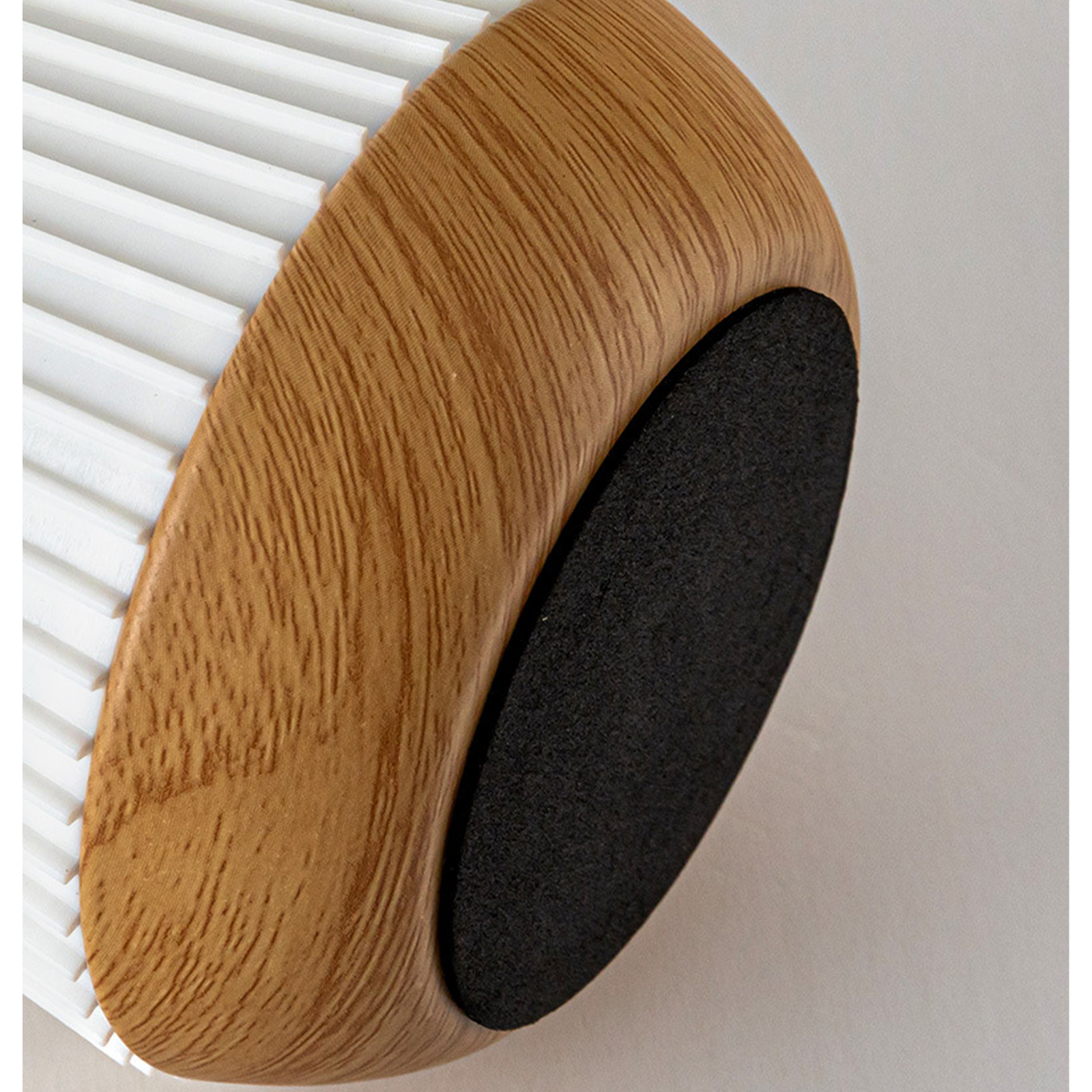 Nahaufnahme eines Holz- und weißen Pinselbodens mit einem schwarzen runden Pad.