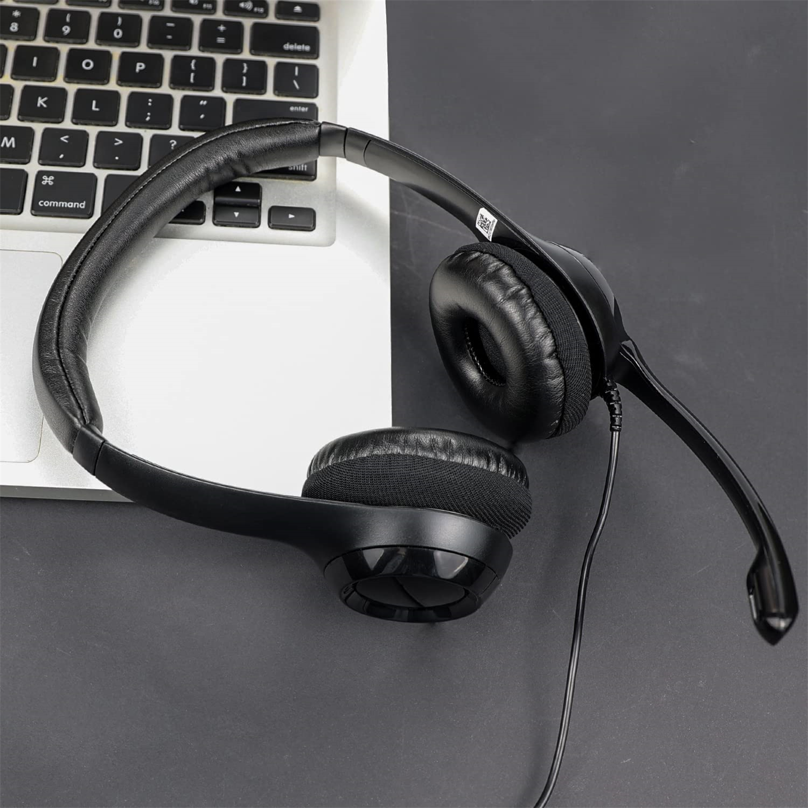 Schwarzes Headset mit Mikrofon, das auf einer Laptop-Tastatur liegt.
