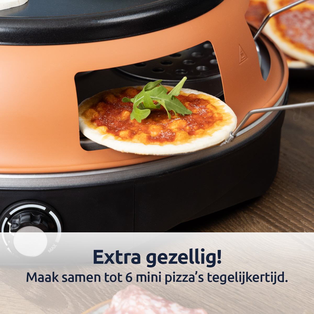 Un mini four à pizza avec une pizza à l'intérieur. Roquette sur le dessus.