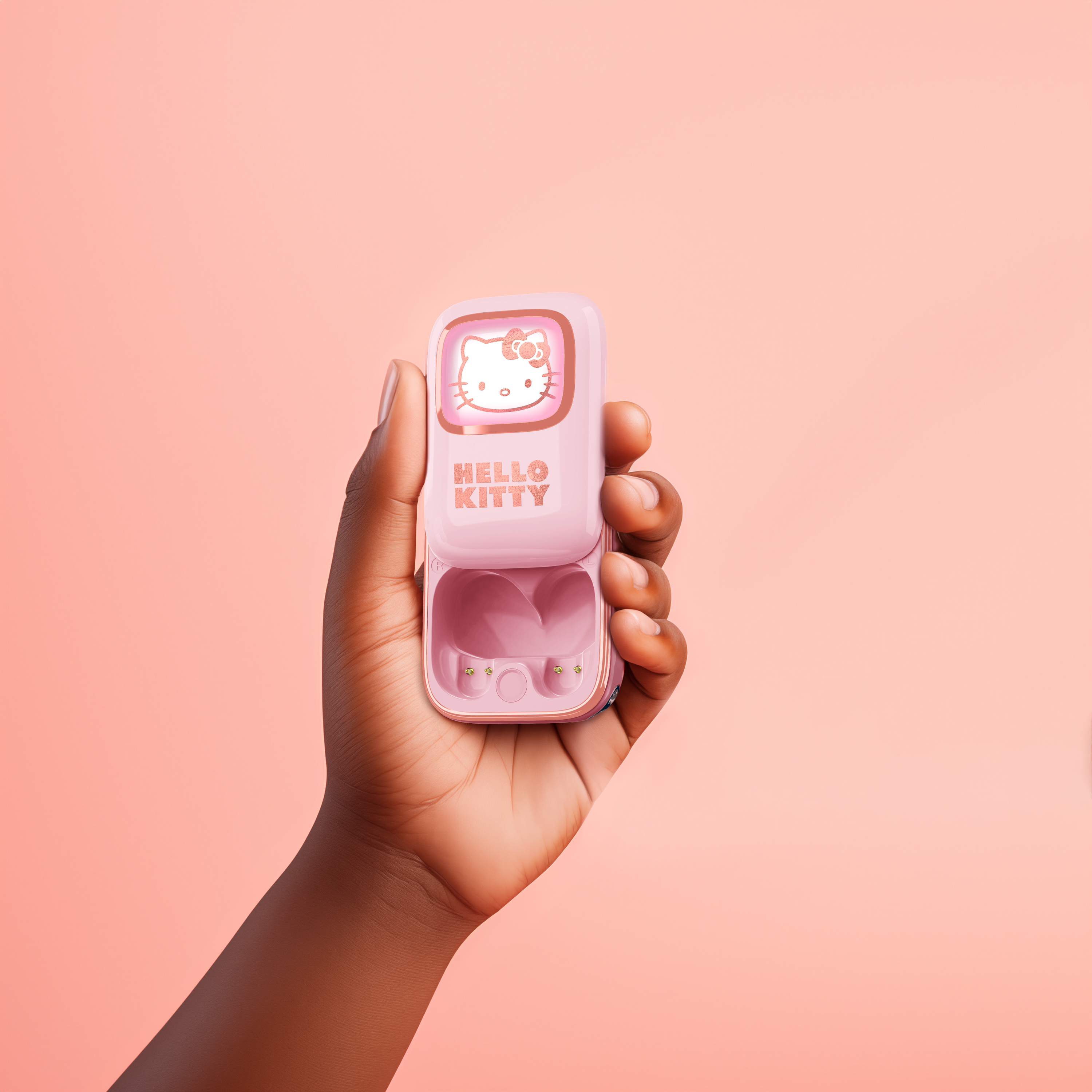 Dłoń trzymająca różowe etui Hello Kitty na różowym tle.