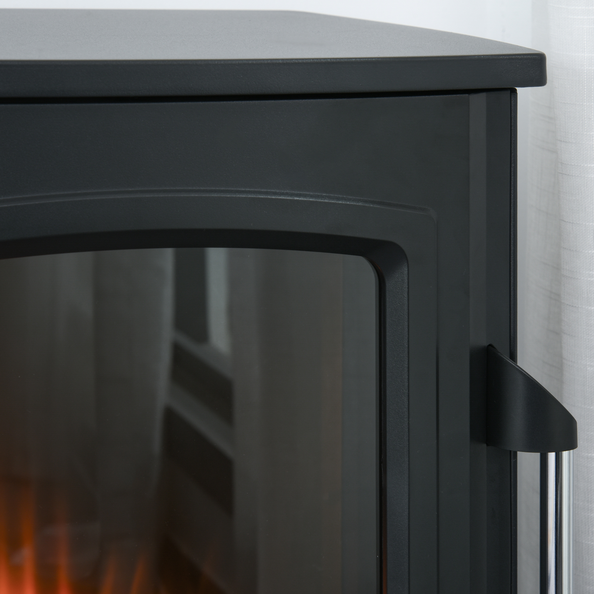Nahaufnahme eines schwarzen, modernen Elektrokamins mit Glasfront und Metallgriff.