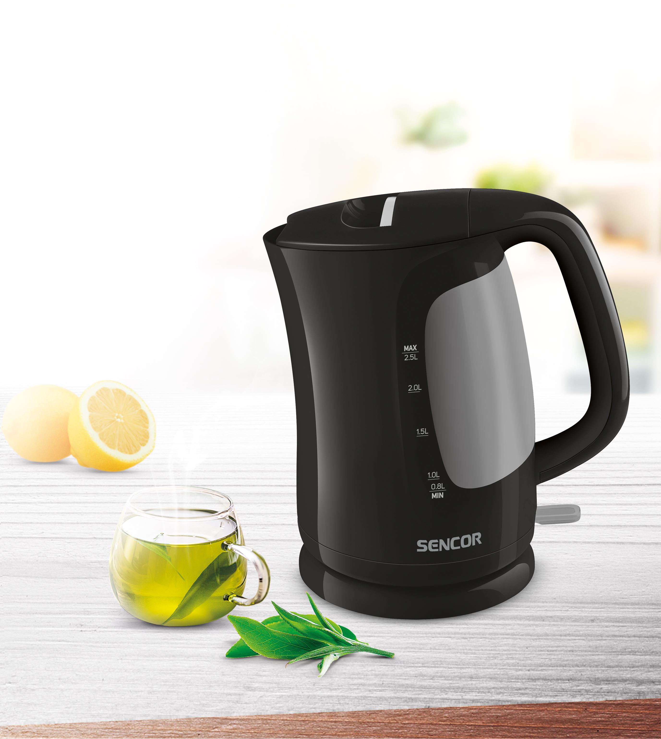 Un bollitore elettrico nero con indicatori di misurazione. Un bicchiere con tè e limoni.