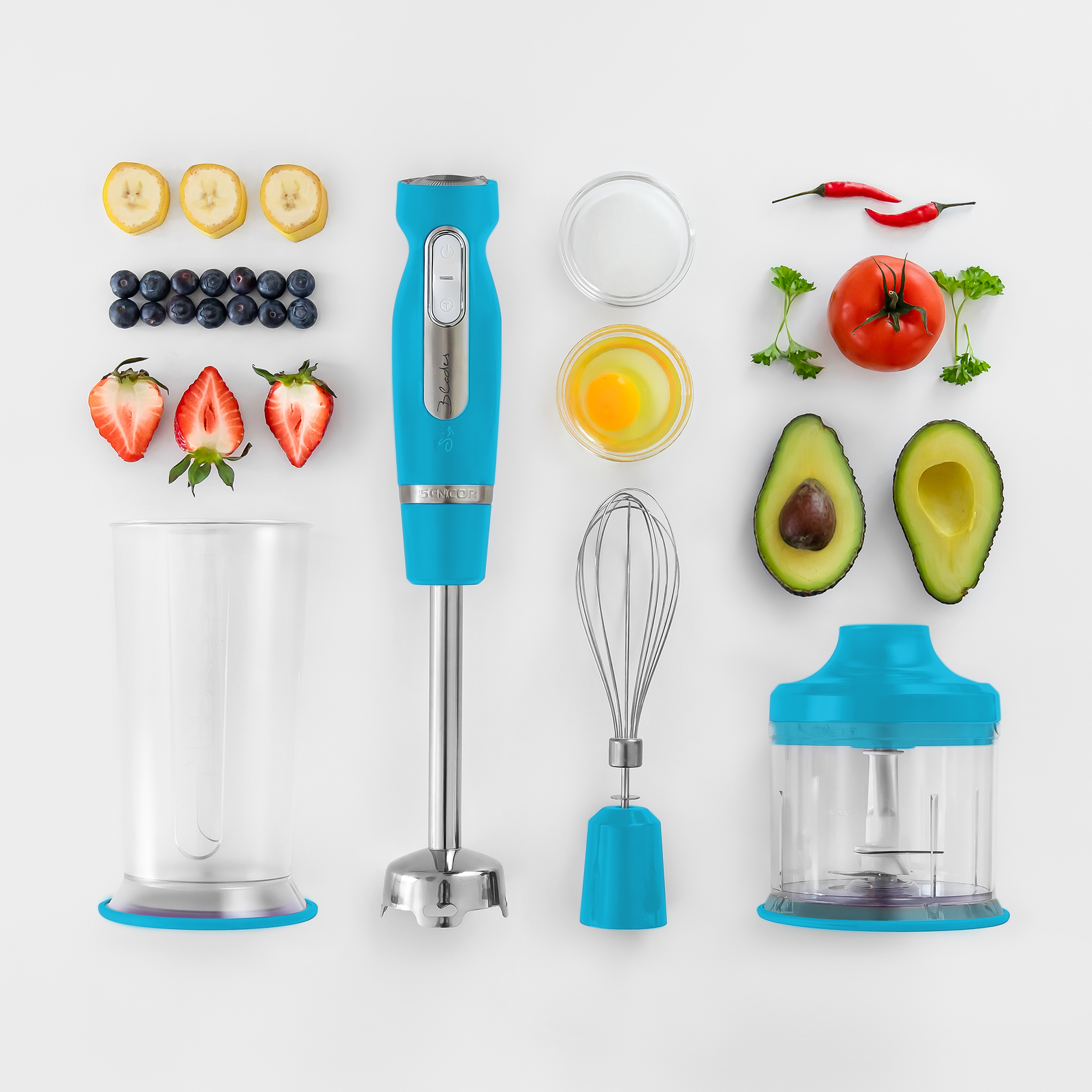 Una collezione di cibo e un frullatore, tra cui banane, mirtilli, fragole, peperoncini e un uovo.