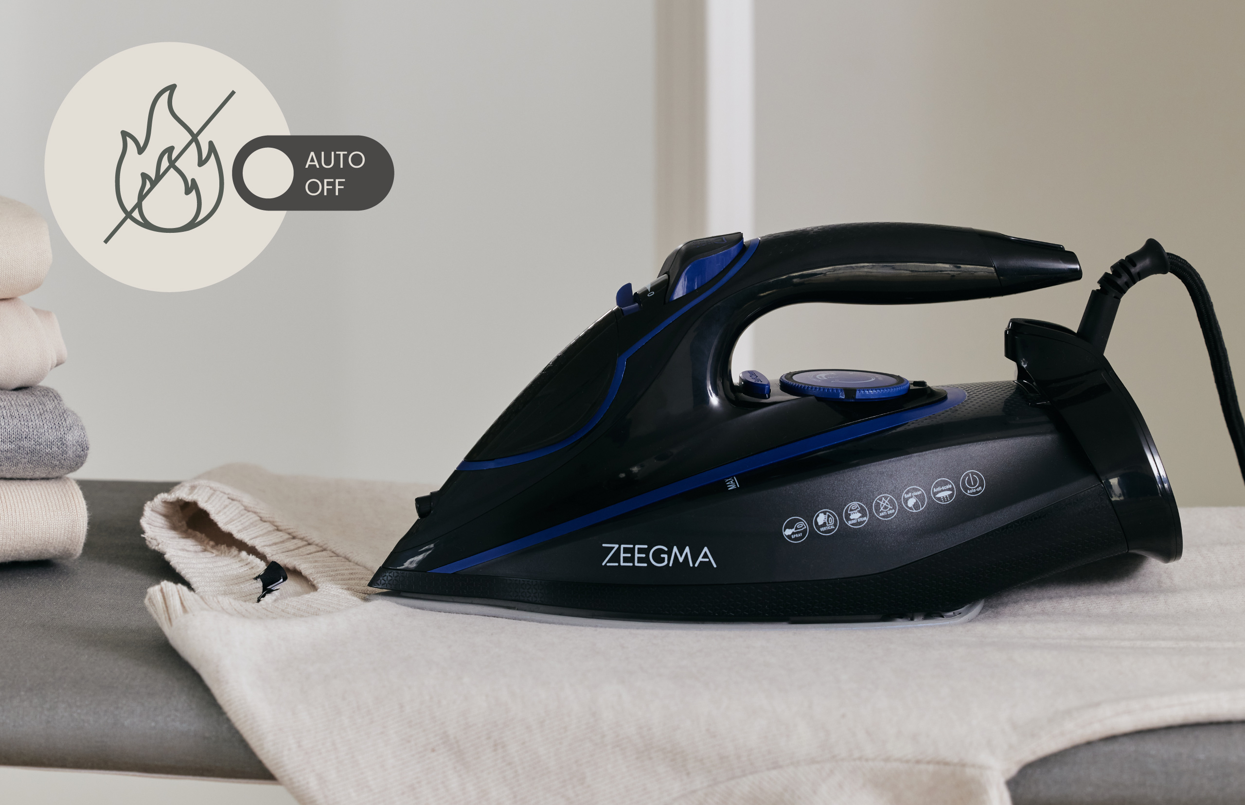 Czarne żelazko prasuje sweter. Widoczny symbol automatycznego wyłączania.