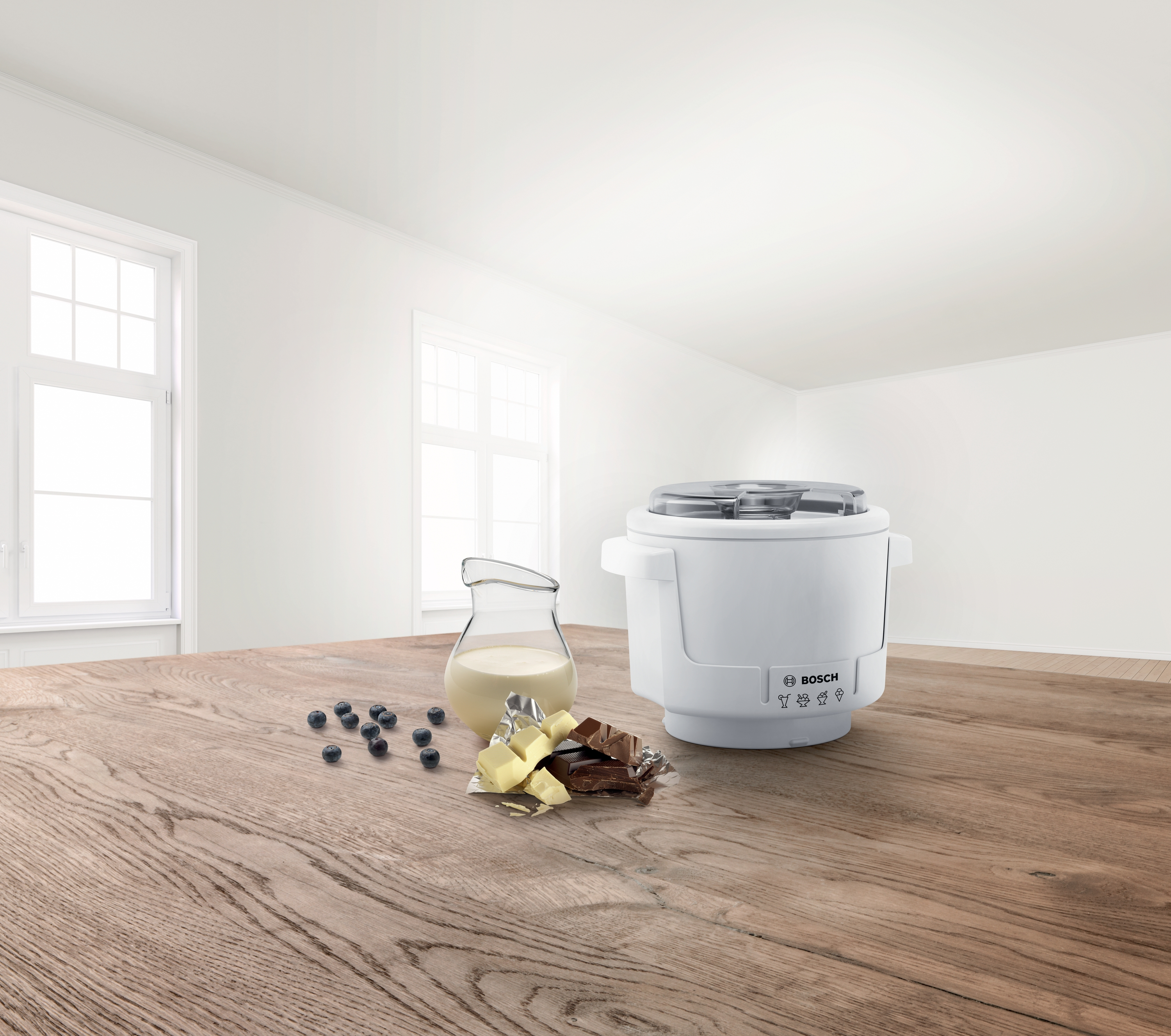 Biała maszyna do lodów ze składnikami takimi jak czekolada, mleko i borówki na drewnianym stole.