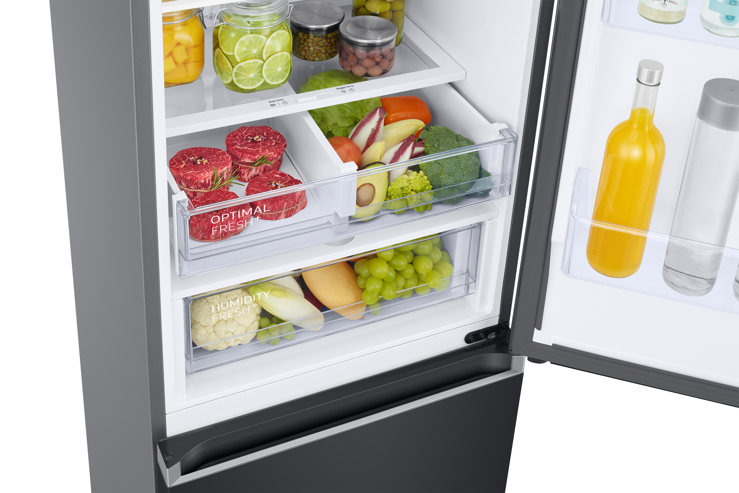 Interno del frigorifero con cassetti contenenti alimenti. Frutta fresca e carne sono visibili.