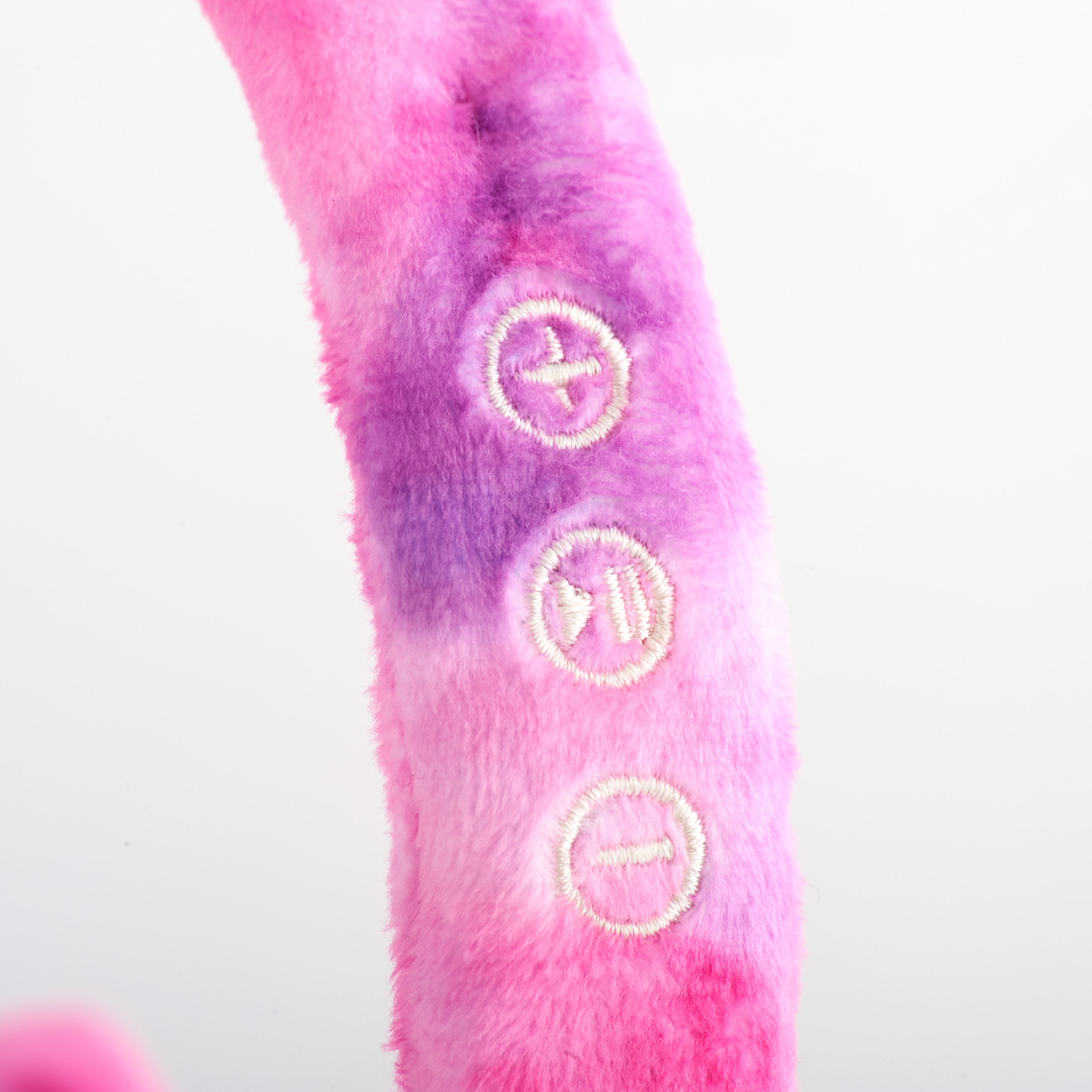 Close-up van roze en paarse fuzzy koptelefoon met volumeknoppen.
