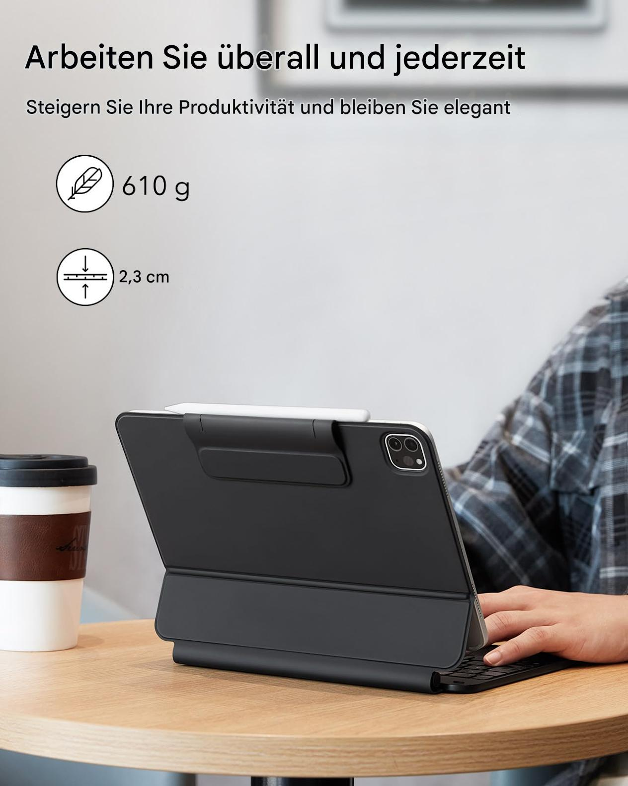 Ein Tablet mit Tastaturhülle auf einem Schreibtisch, neben einer Kaffeetasse. Text auf Deutsch.
