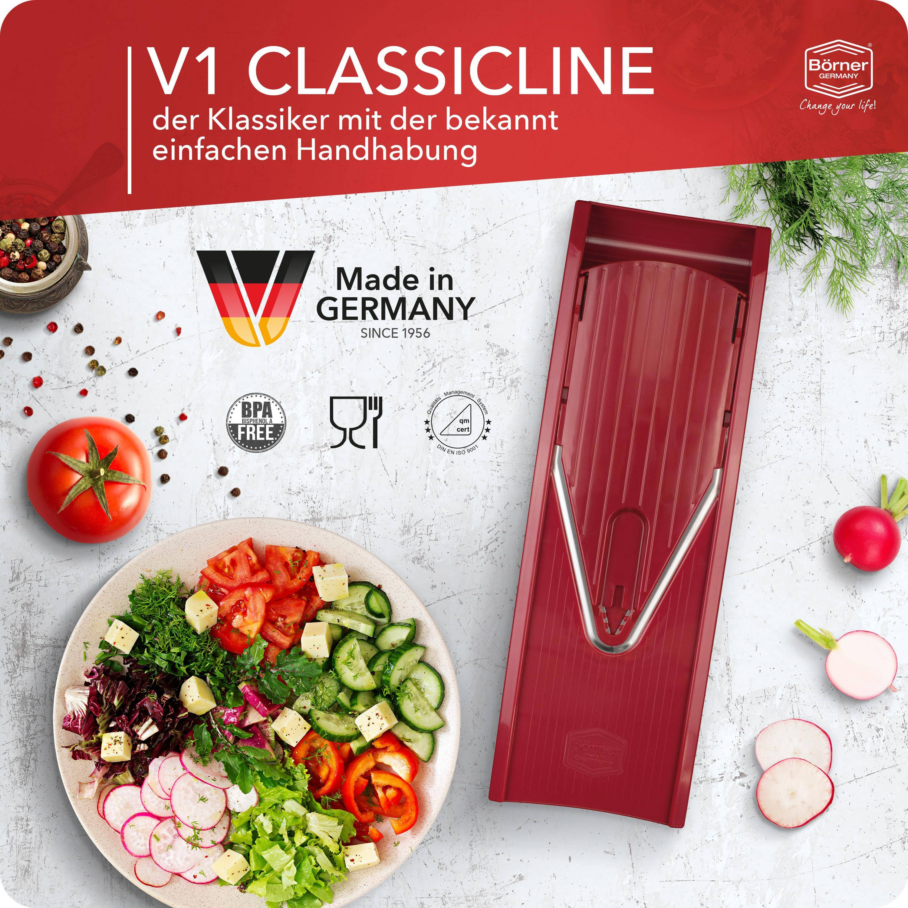Roter V1 Classicline Gemüseschneider mit Gemüse und Zutaten drumherum.