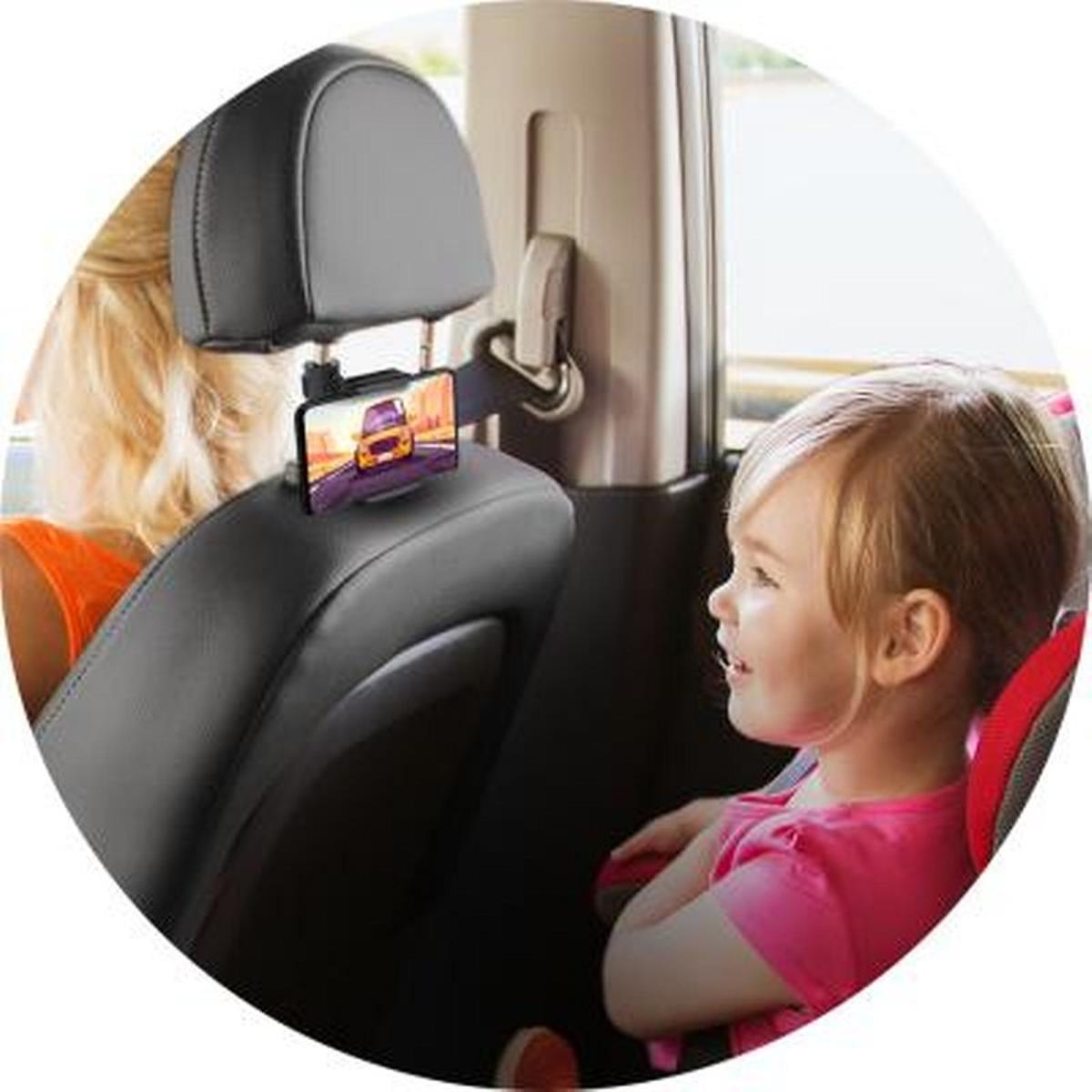 Una bambina guarda un telefono attaccato al poggiatesta dell'auto. Una donna è nel sedile anteriore.