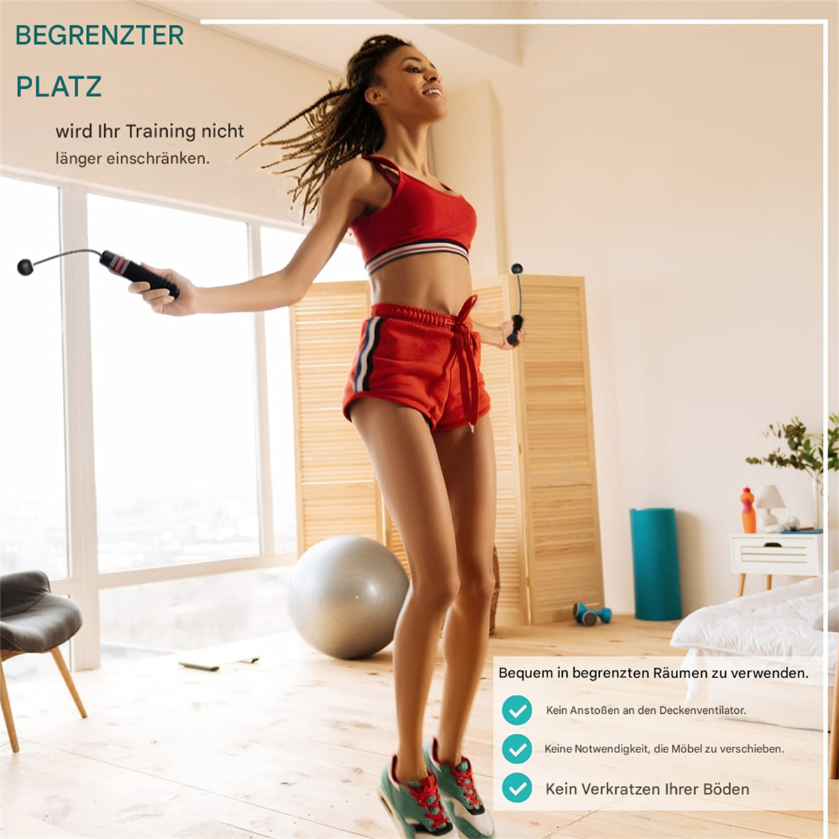 Frau springt Seil. Rote Shorts, Sport-BH. Holzboden, Fenster, Fitnessball und eine Raumaufteilung.