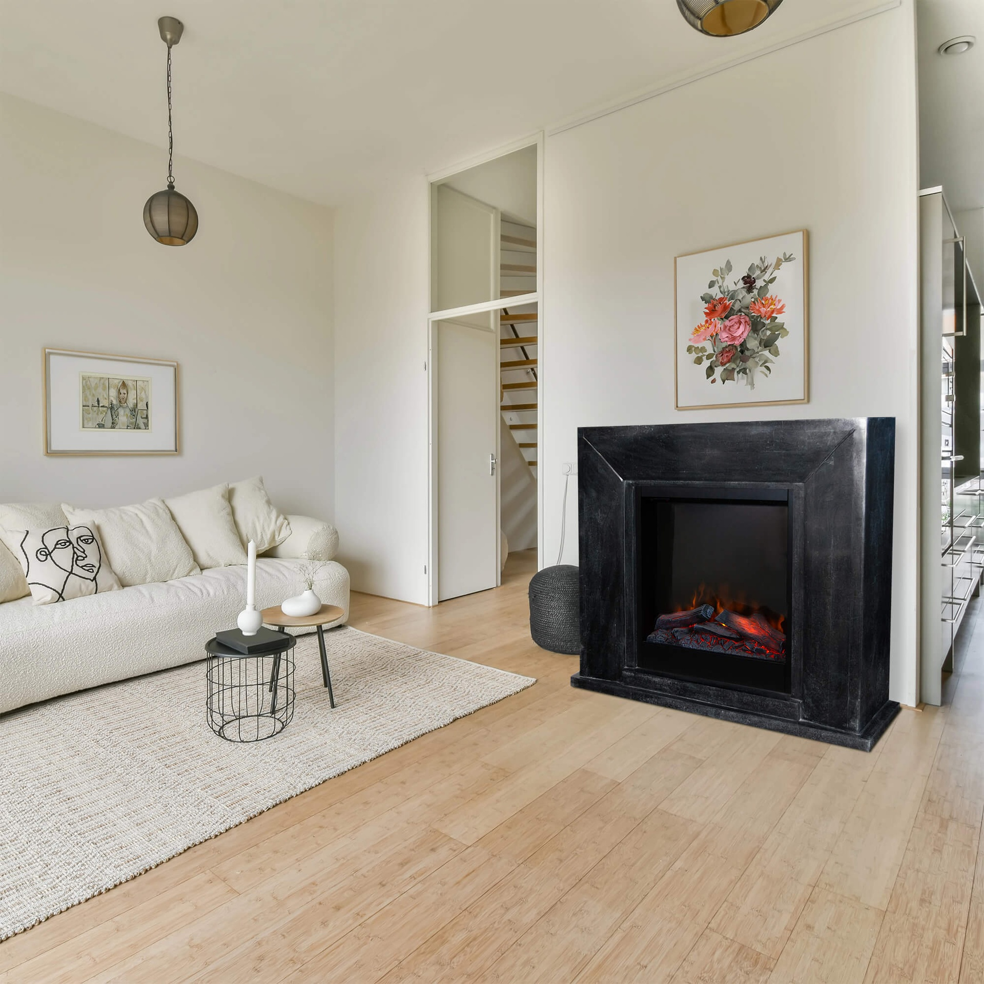 Woonkamer met witte bank, zwarte open haard, bloemenkunst en houten vloer. Inclusief een vloerkleed, tafels en een hanglamp.
