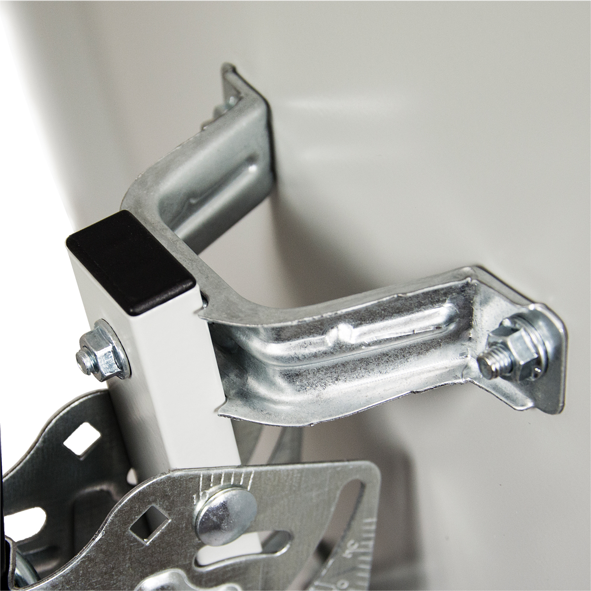 Nahaufnahme einer Metallhalterung mit Schrauben und einem schwarzen Gummiteil.