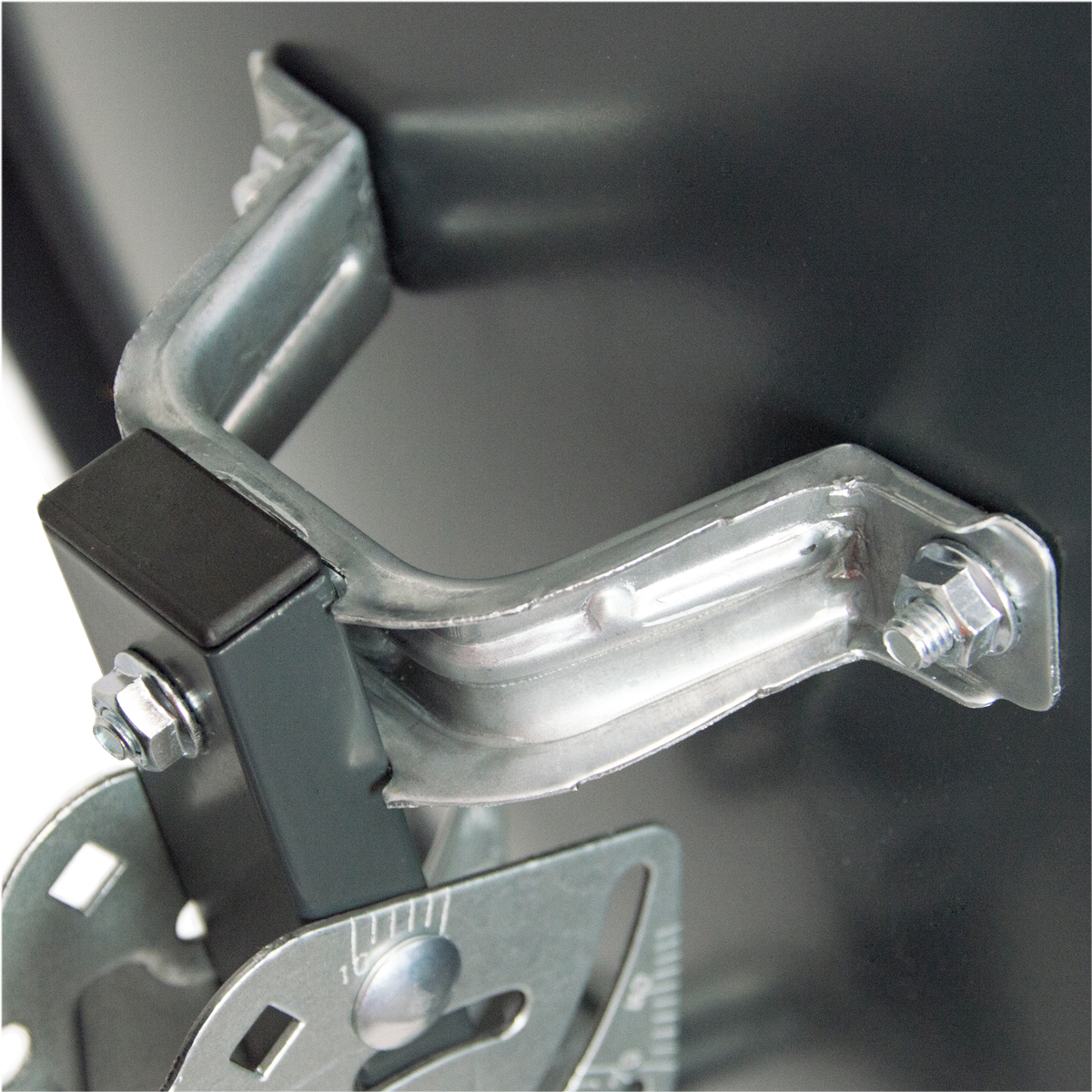 Eine Metallhalterung mit Schrauben und einem Gummipolster, befestigt an einer dunklen Oberfläche.