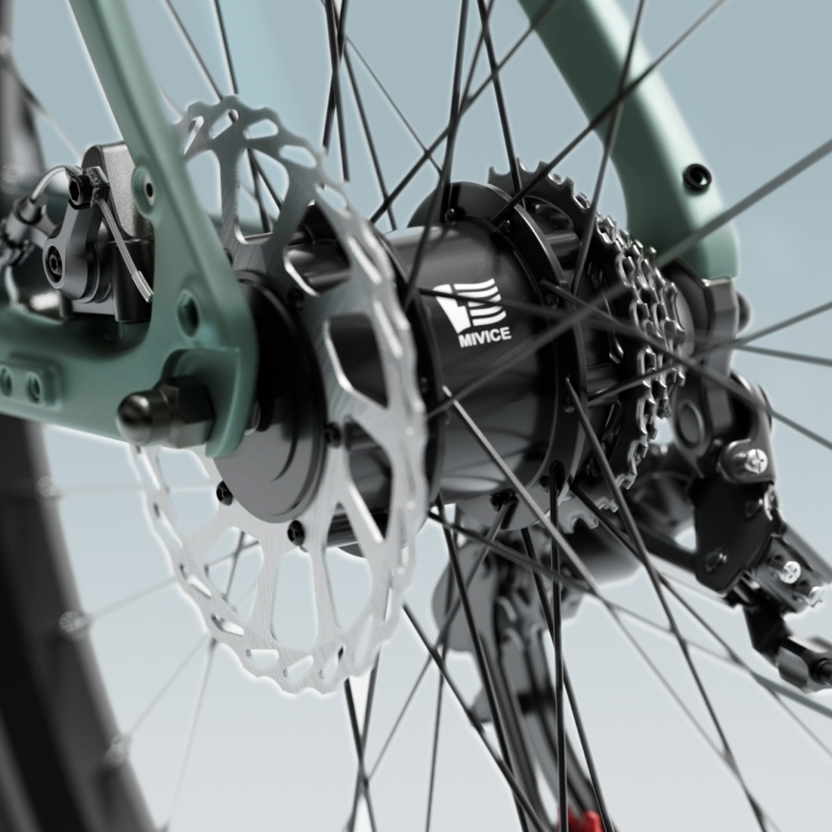 Zbliżenie koła roweru z hamulcami tarczowymi i piastą Mivice, na jasnoniebieskim tle.