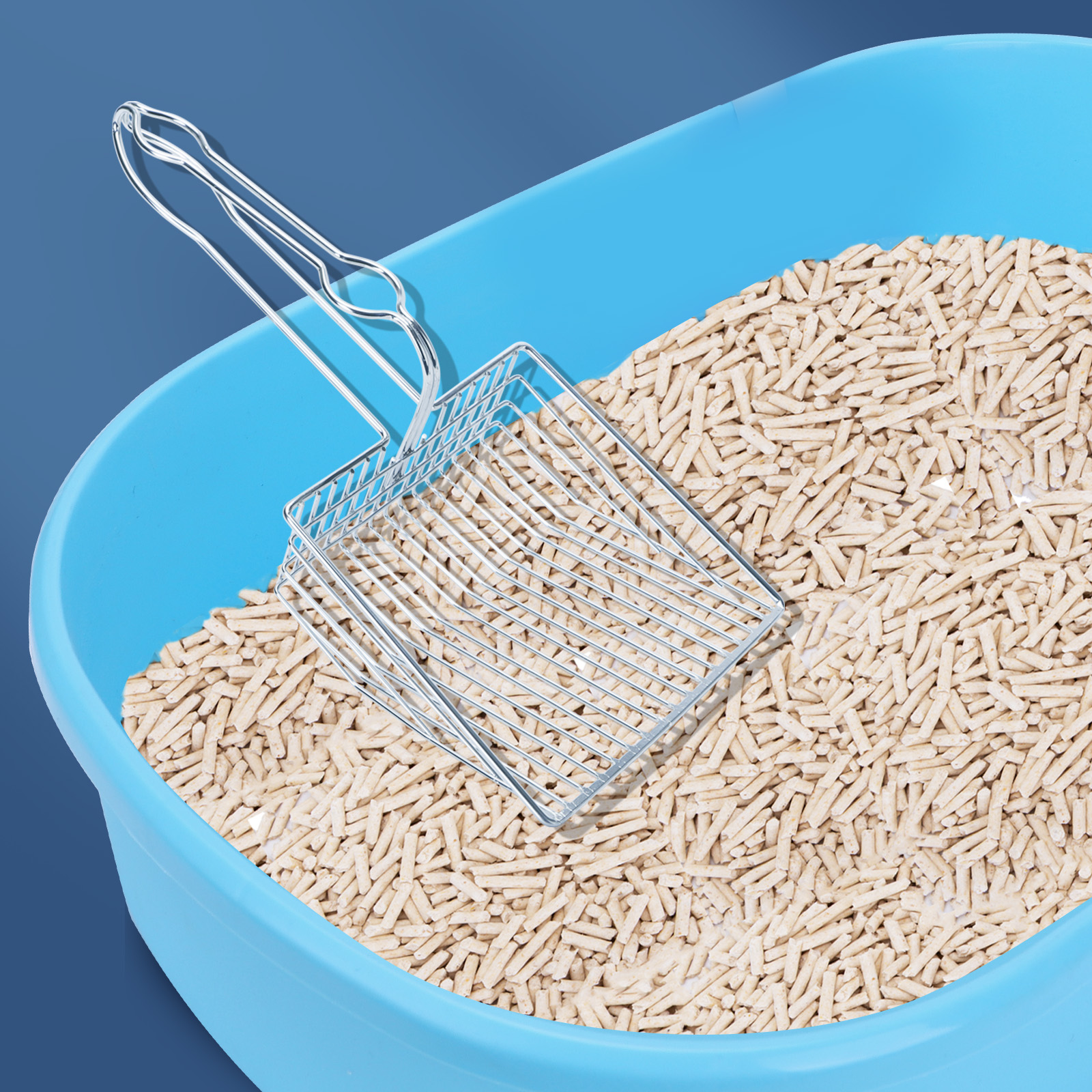 Una caja de arena azul llena de arena beige y una pala plateada. La pala está en la arena.