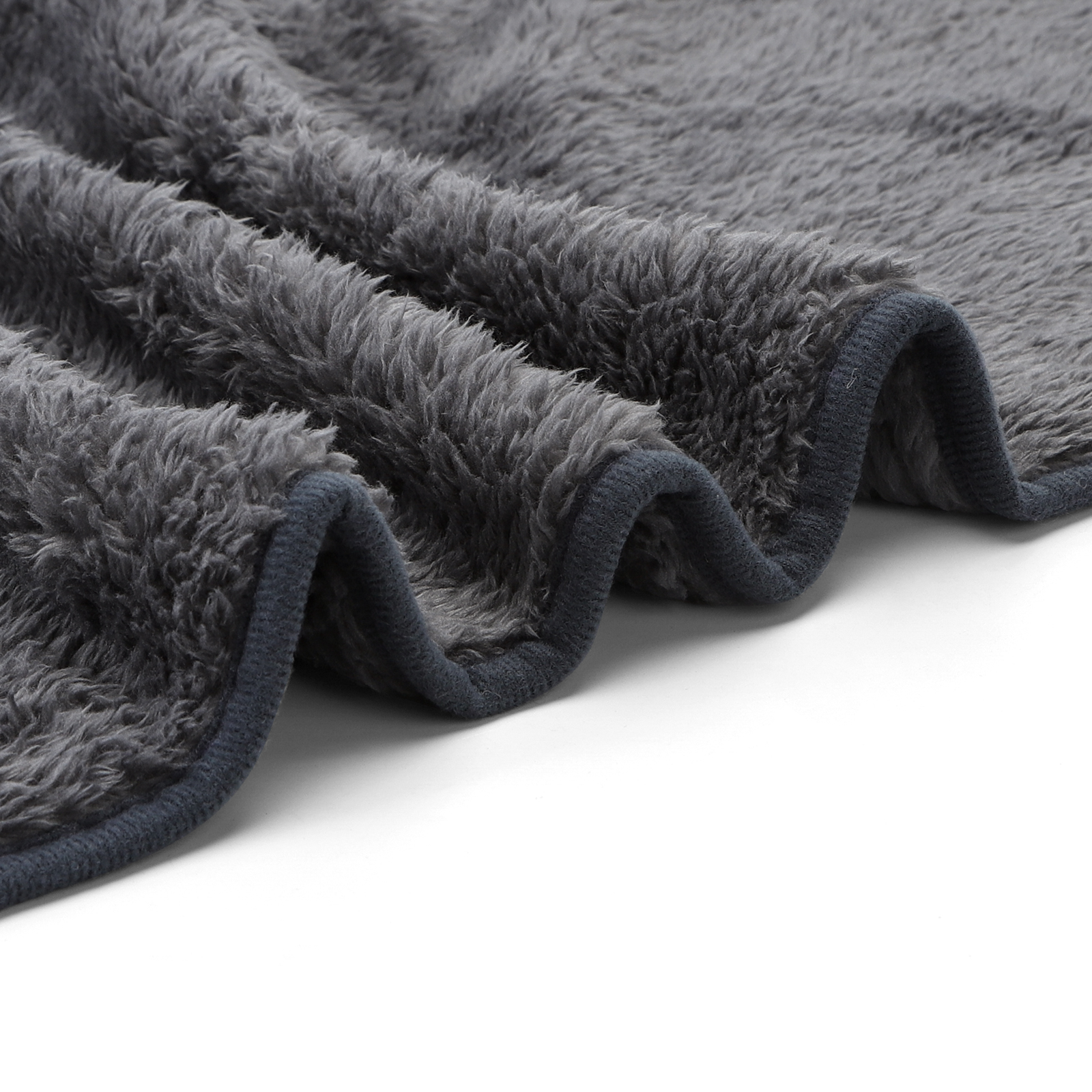 Primer plano de una manta o frazada gris y esponjosa con borde gris oscuro.