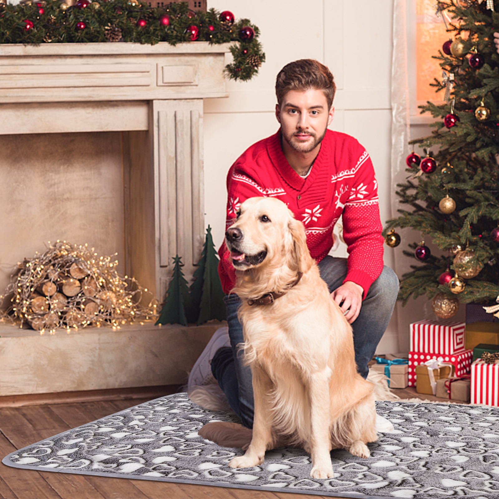 Un hombre y un perro golden retriever cerca de una chimenea y un árbol de Navidad.