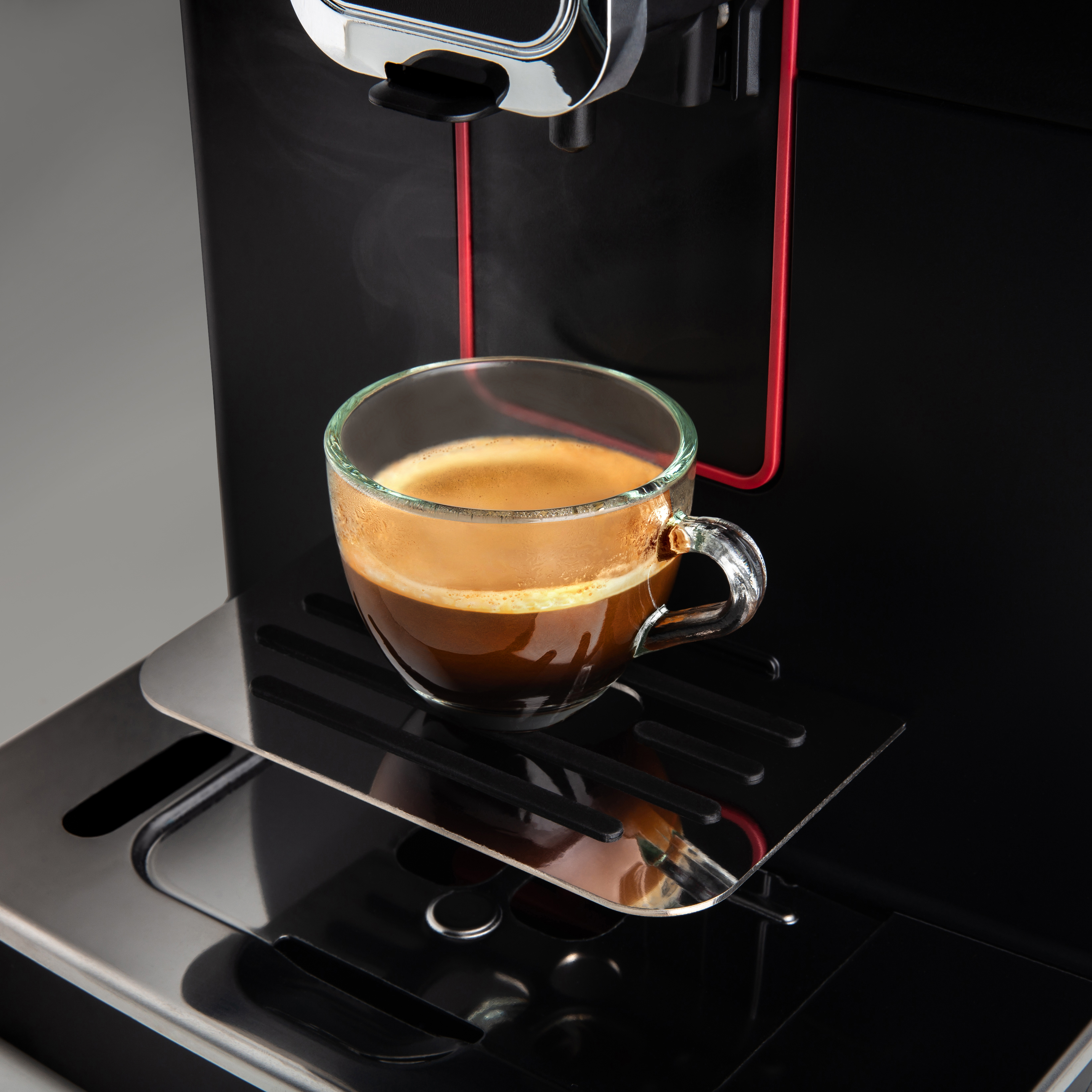 Eine Tasse Kaffee befindet sich auf der Platte der Maschine.