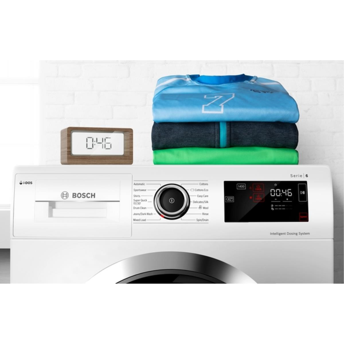 Eine Waschmaschine mit Kleidung und einer Digitaluhr oben, die Maschine ist weiß.