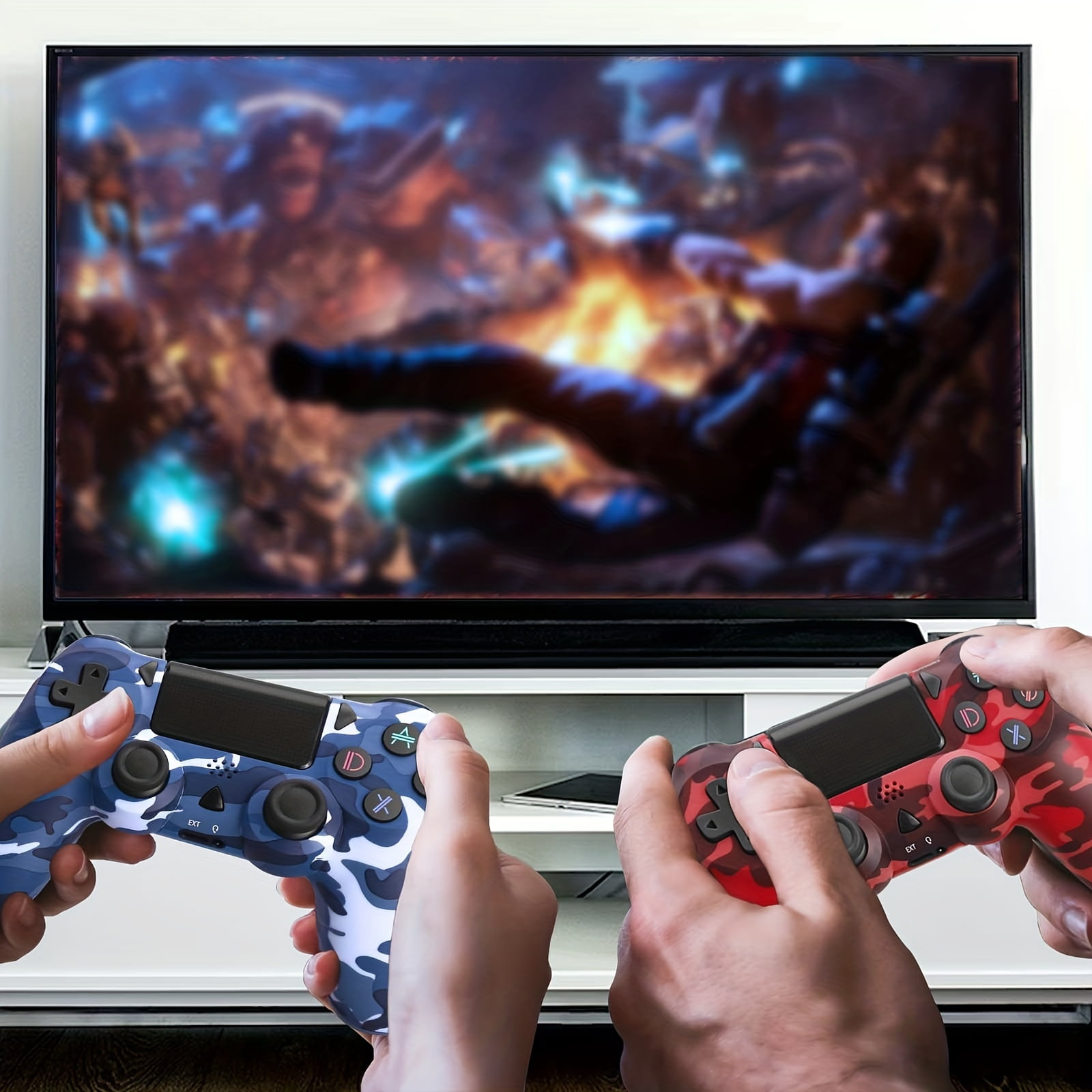Zwei Hände halten Camouflage-Gamecontroller. Der TV-Bildschirm ist unscharf.