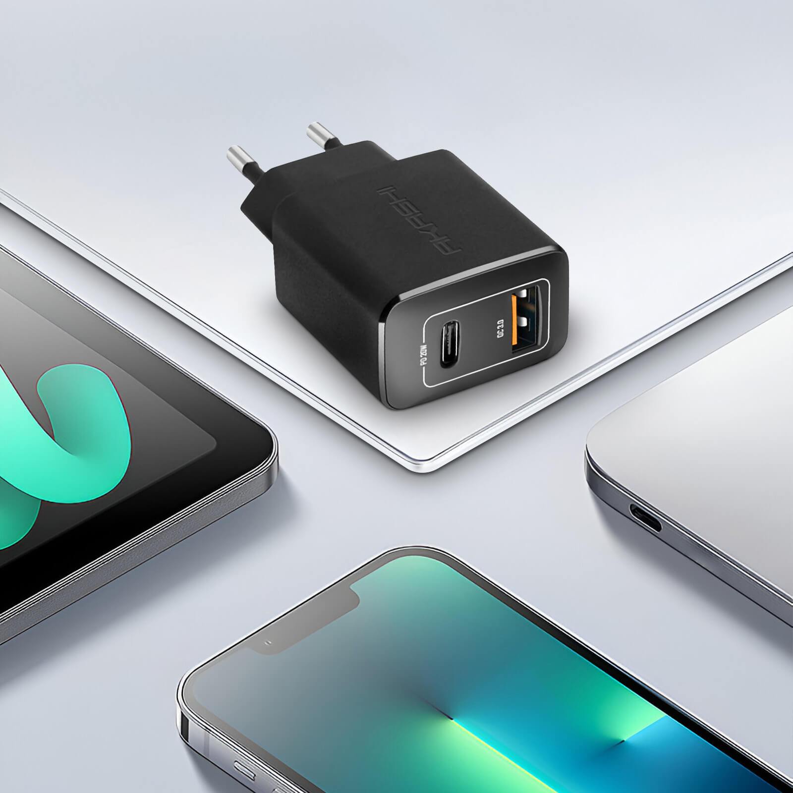 Caricatore nero con porte USB, posizionato su dispositivi elettronici.