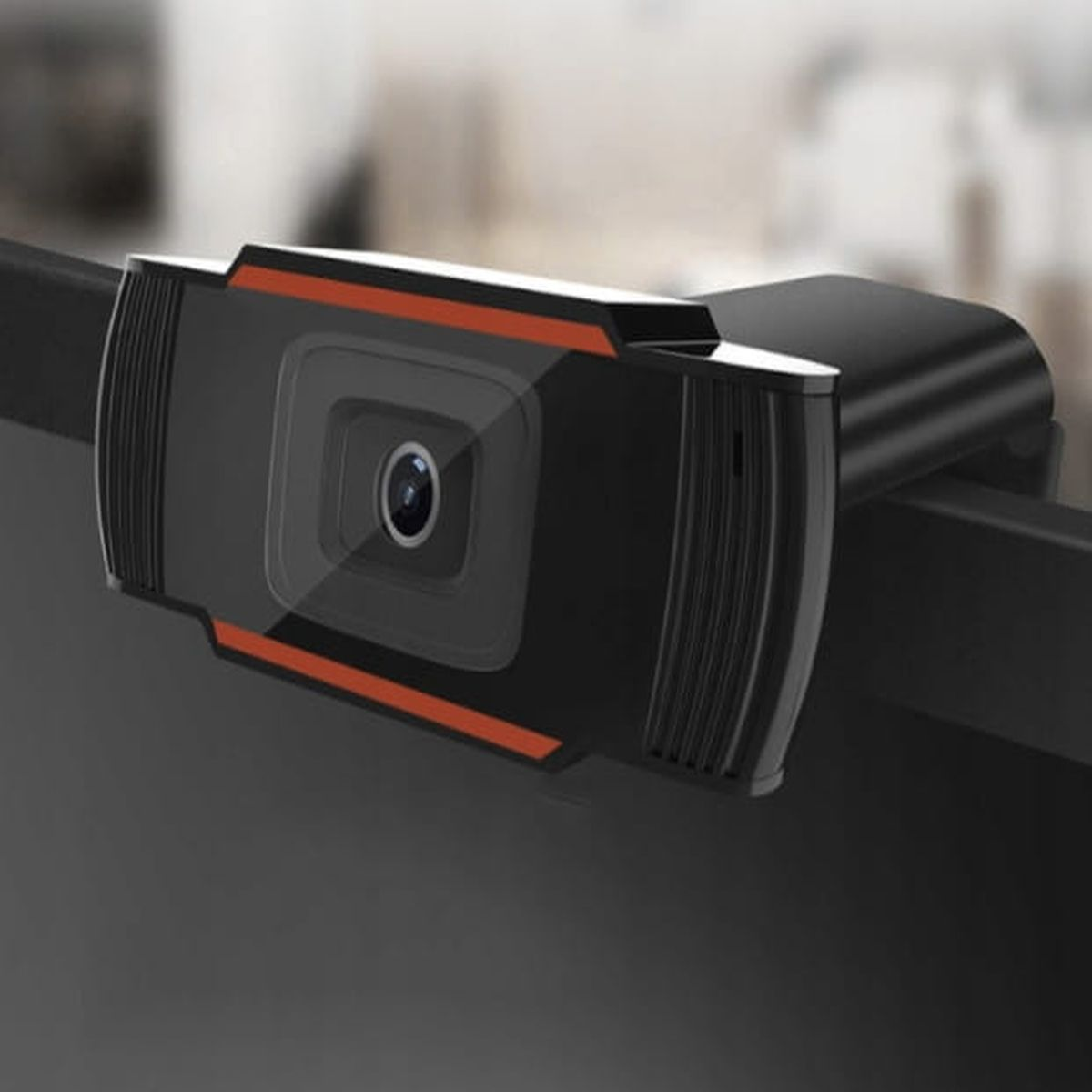 Eine schwarze Webcam mit rotem Streifen, an einem Monitor befestigt.