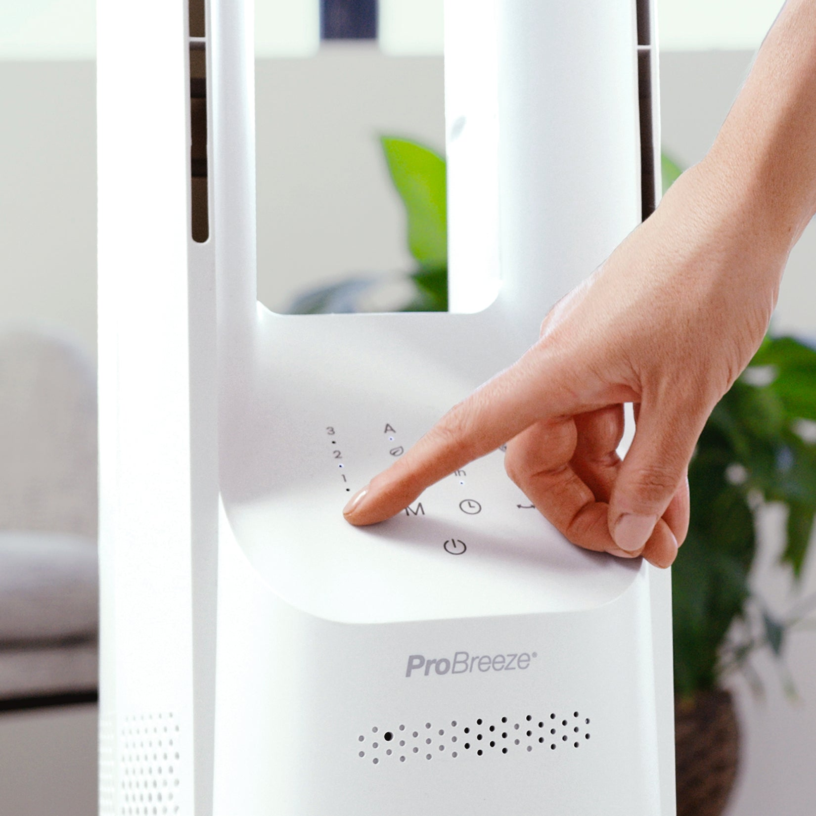 Eine Hand drückt eine Taste auf einem weißen ProBreeze-Lüfter. Der Lüfter hat ein Bedienfeld mit mehreren Einstellungen.