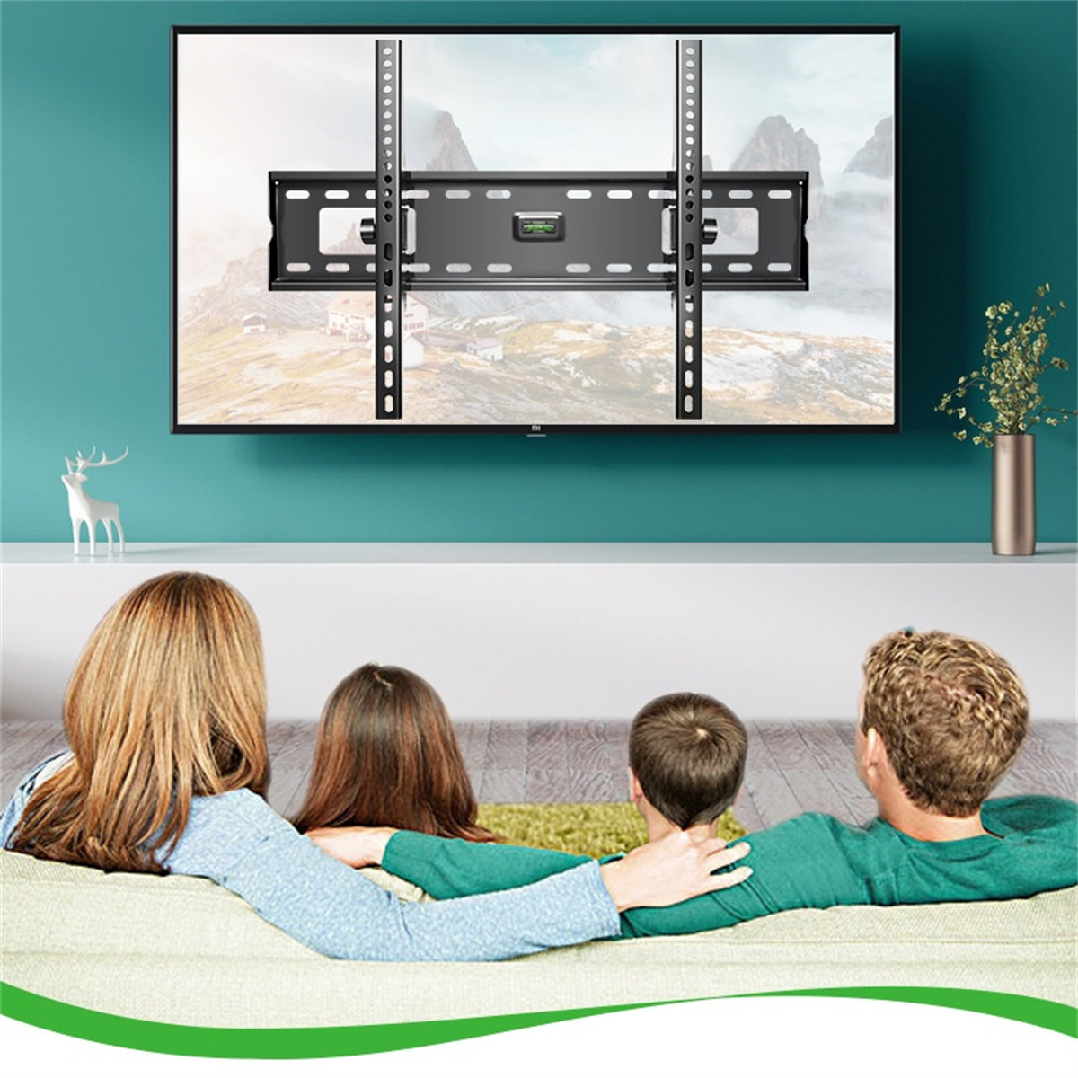 Familie schaut fern. Fernseher an der Wand montiert. Weißes Regal. Grüner Teppich. Blaue Wand.