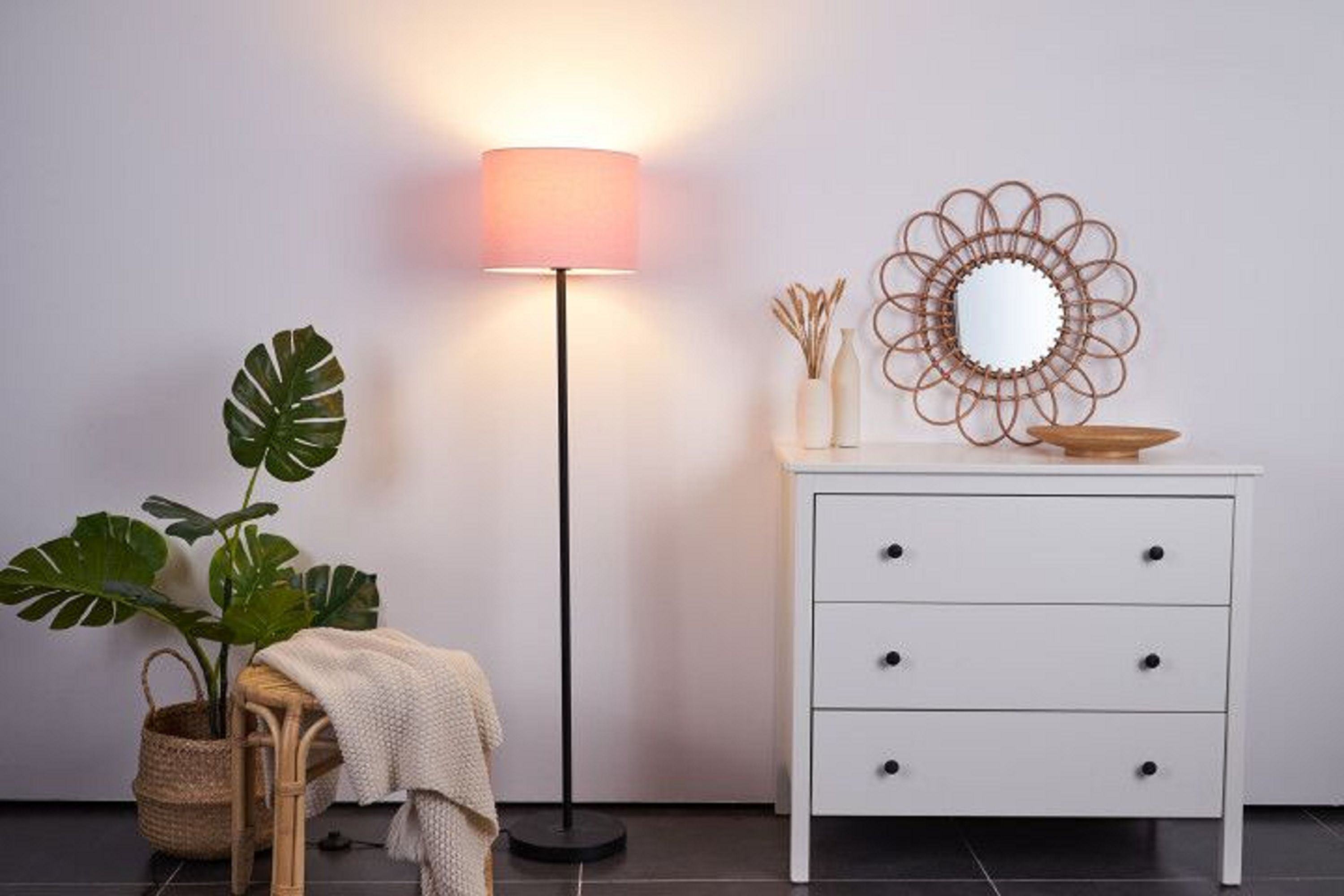 Pokój z lampą, komodą, lustrem i rośliną.