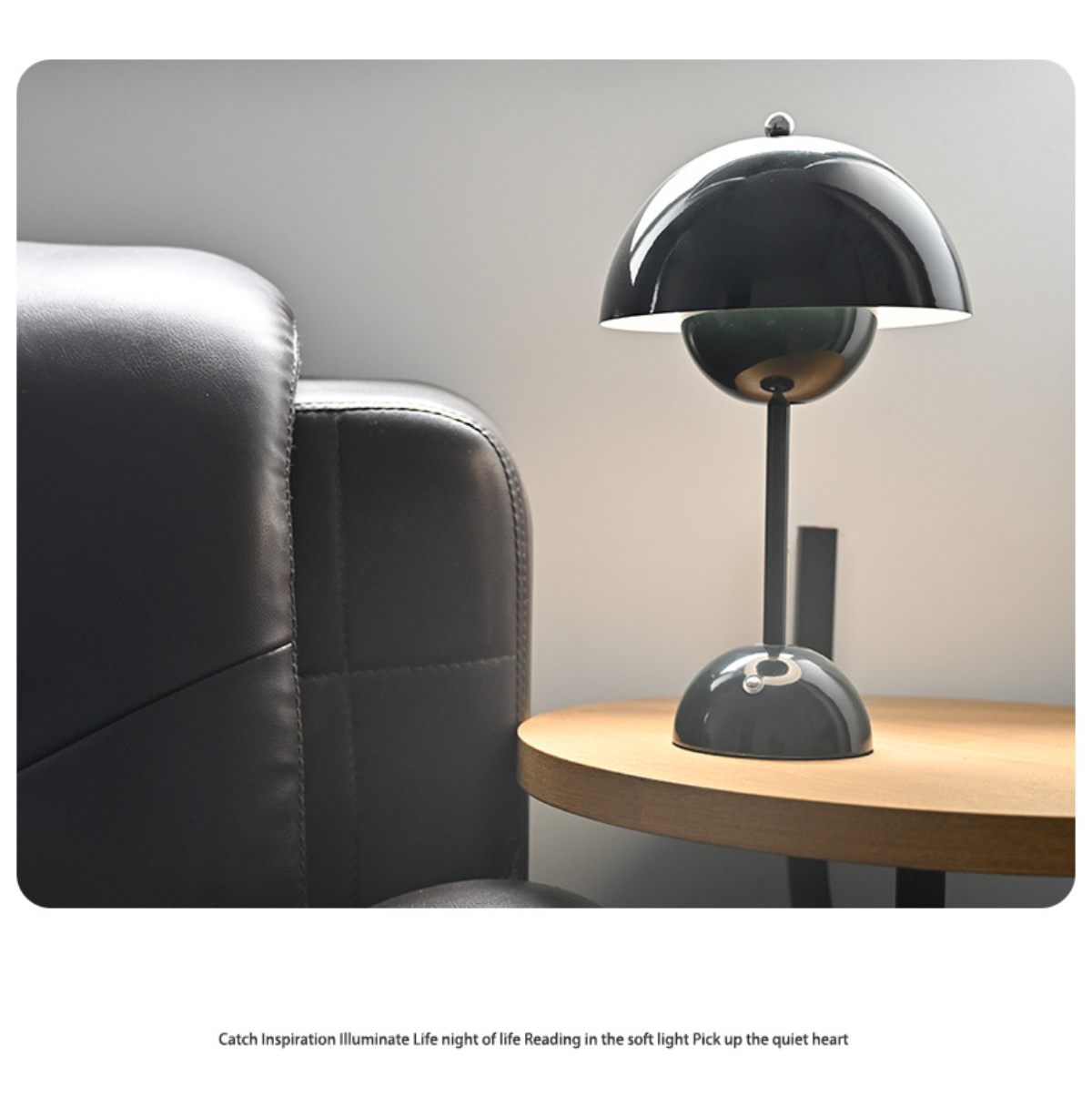 Eine moderne, dunkel gefärbte Schreibtischlampe auf einem Tisch neben einem dunklen Ledersofa.