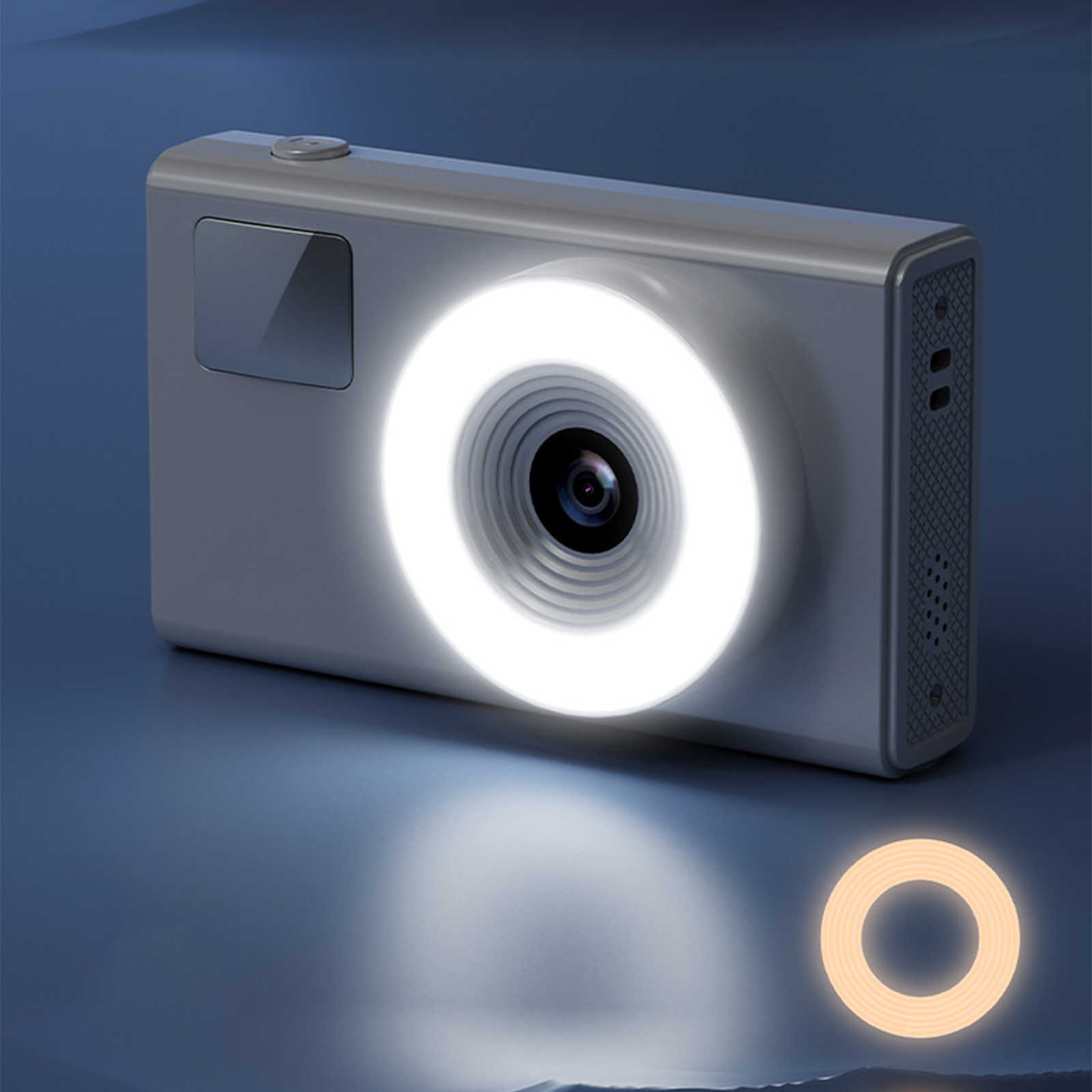 Graue Kamera mit Ringlicht auf blauem Untergrund. Ein Ringlicht befindet sich unten.
