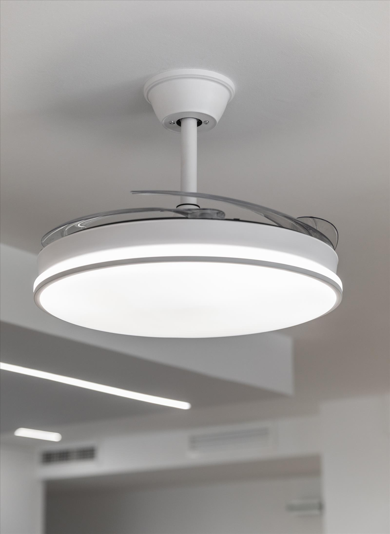 Ventilador de techo blanco con luz. Diseño moderno, accesorio blanco, luz brillante.