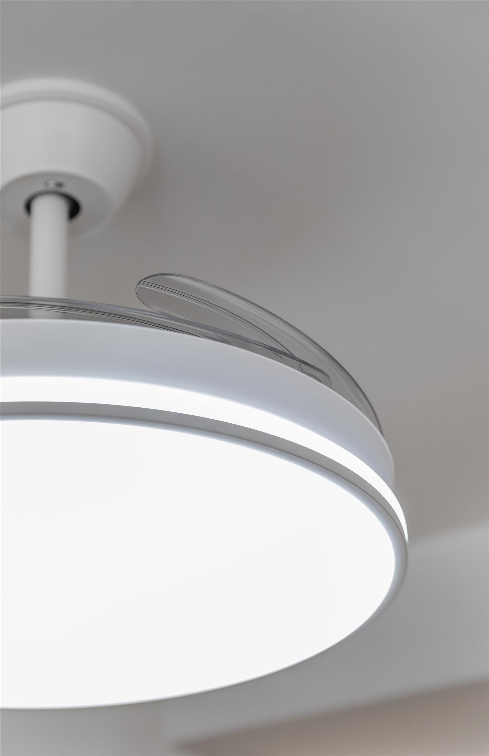 Primer plano de un ventilador de techo blanco con luz brillante y diseño de aspas transparentes.