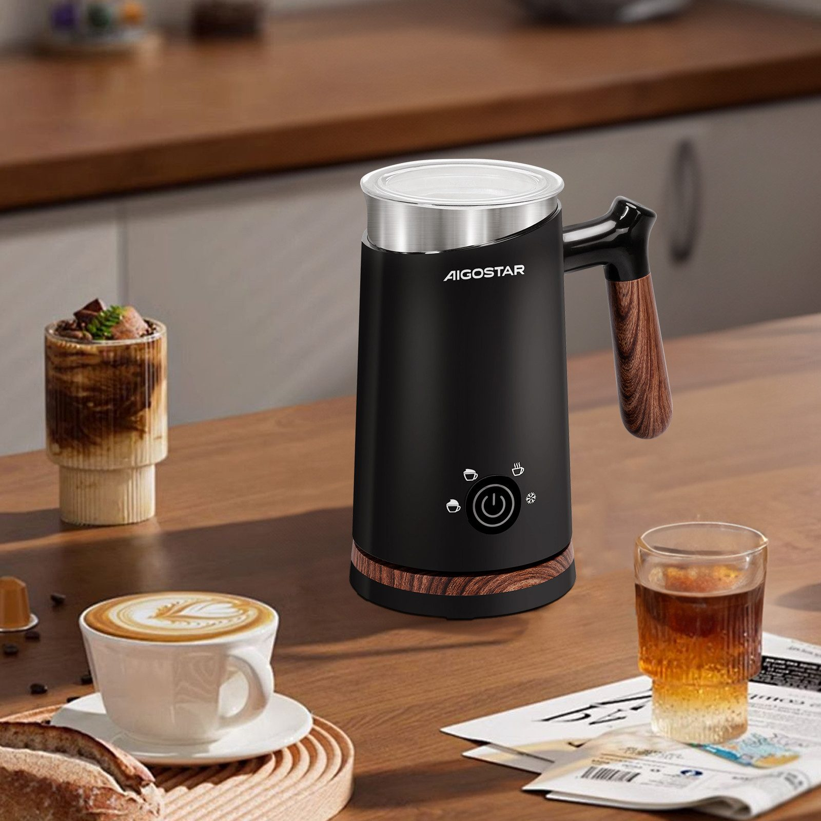 Schwarzer Milchaufschäumer mit Kaffeeutensilien. Holztisch, weiße Tasse.