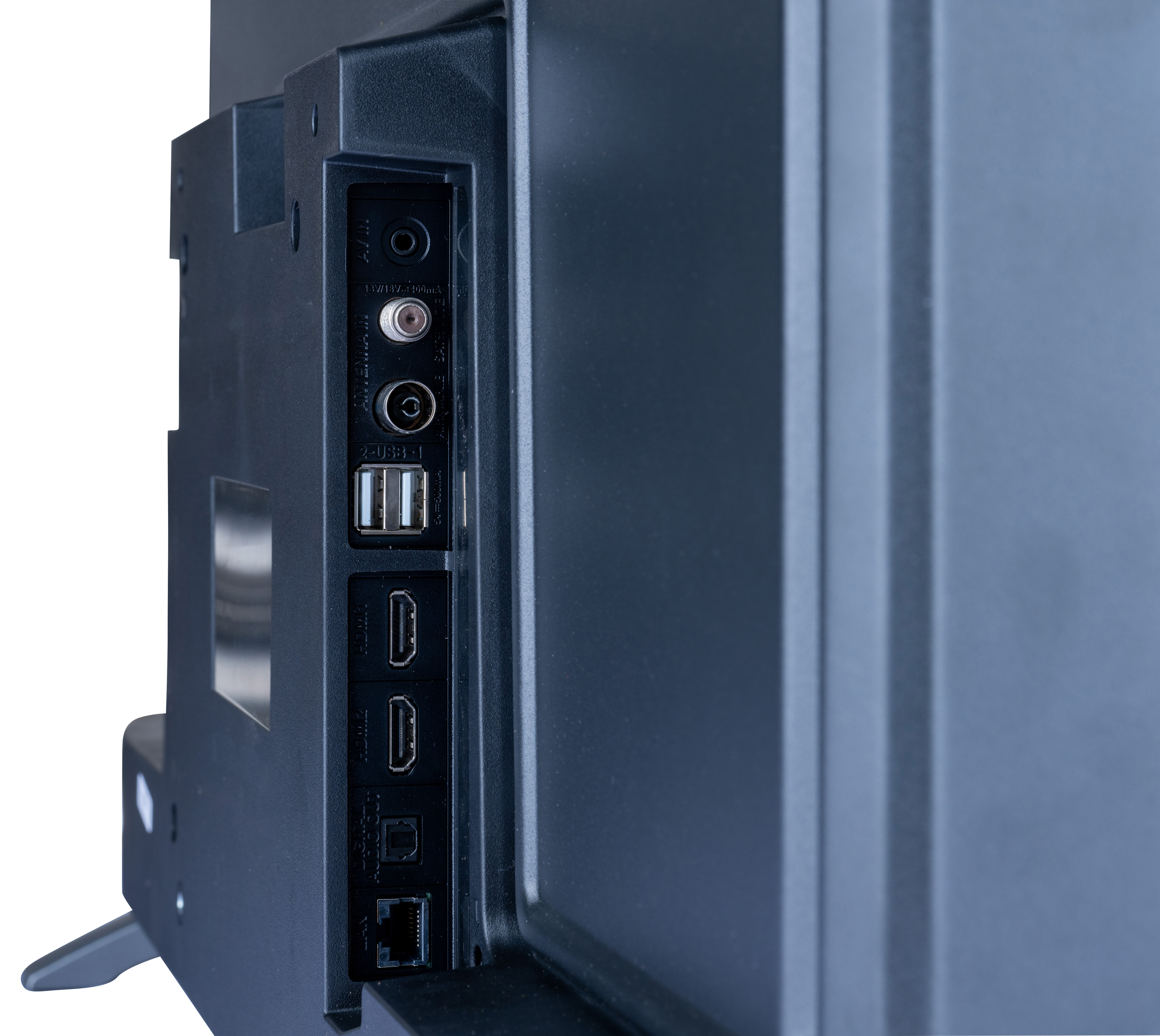 Zbliżenie portów TV: Antena, USB, HDMI, Ethernet. Tył ciemnego telewizora na białym tle.