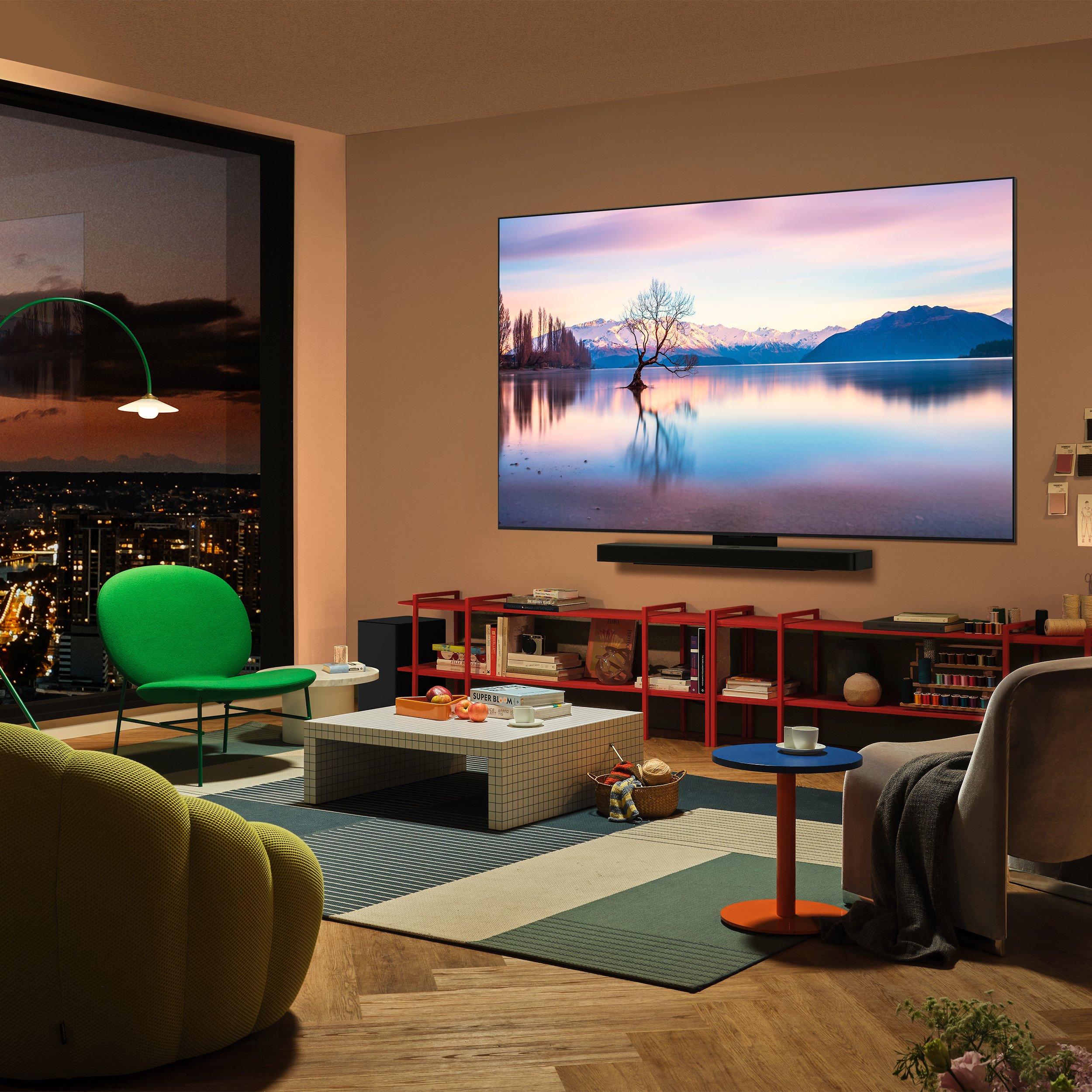 Salon avec une TV affichant une scène de lac. Une chaise verte et une table devant.