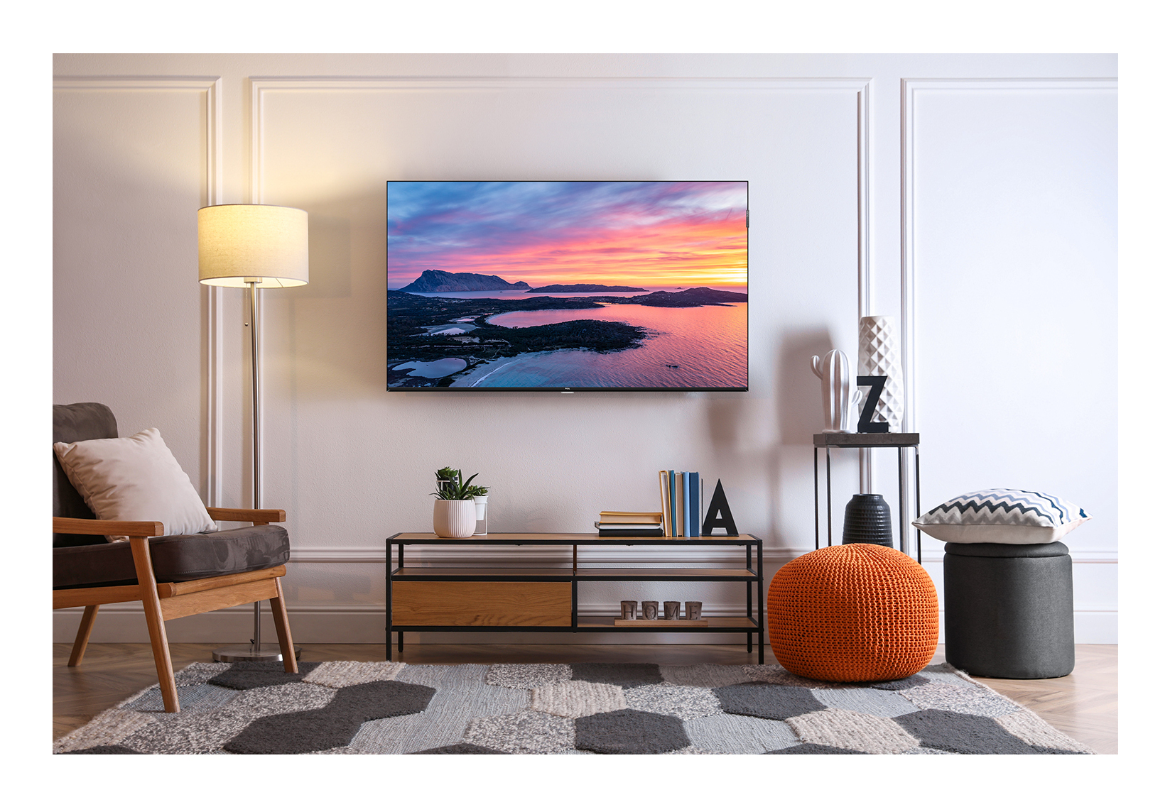 Salon z telewizorem wyświetlającym zachód słońca i dekoracje.